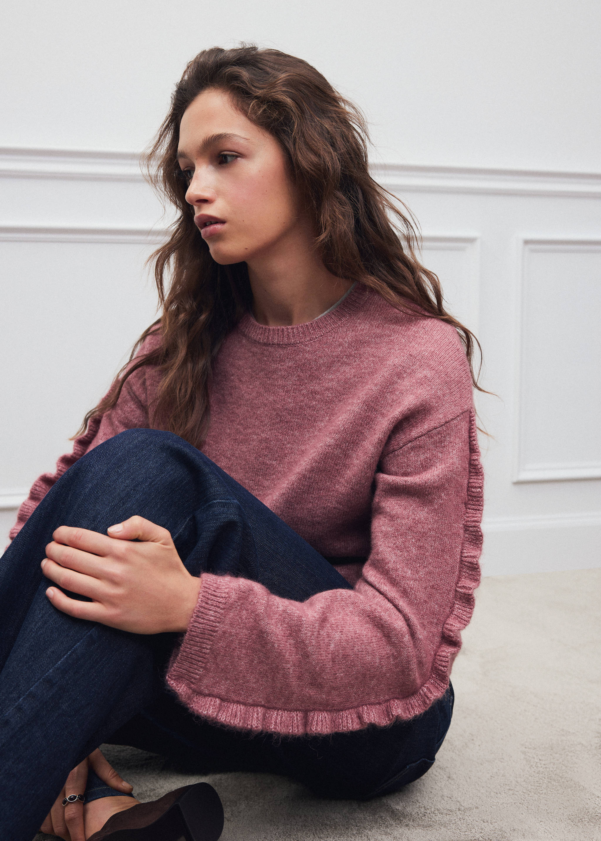 Dusty pink knit jersey with a crew neck and ruffled long sleeves.