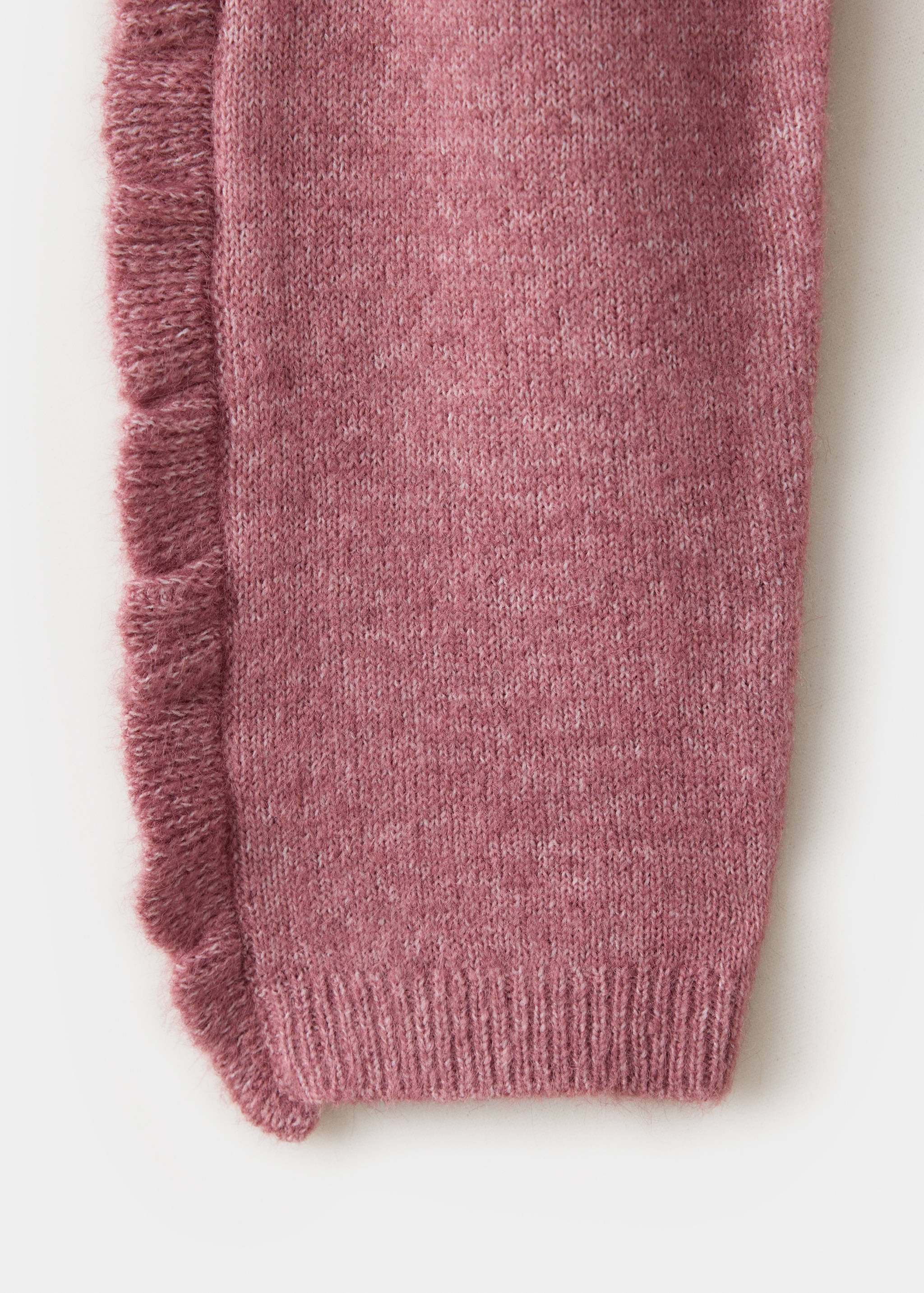 Close-up of a pink knit jumper sleeve with a frill trim.
