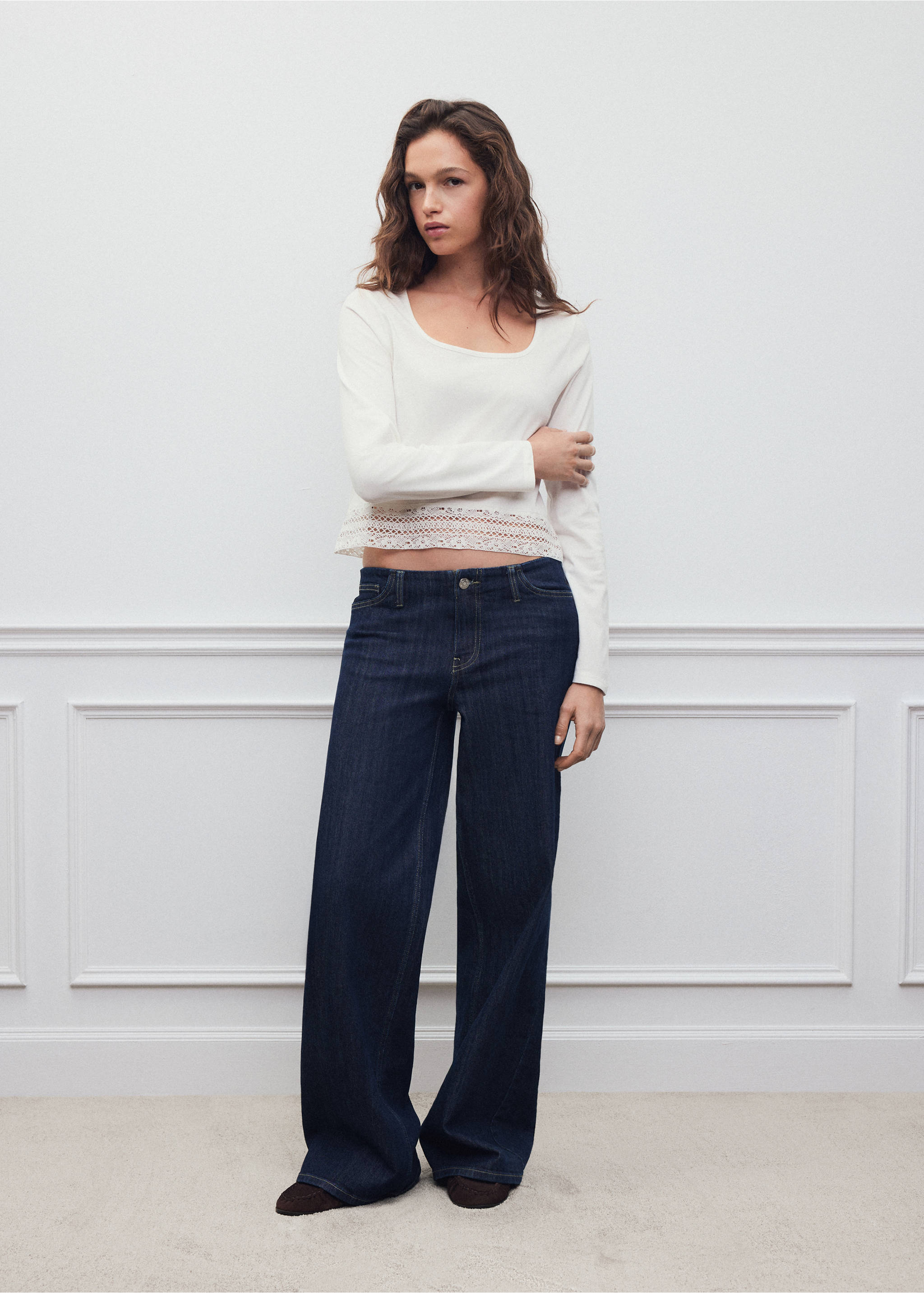 White long-sleeved t-shirt with a scoop neck and lace-trimmed hem, worn with dark blue wide-leg jeans., Off White. Ref: 37008285-00.