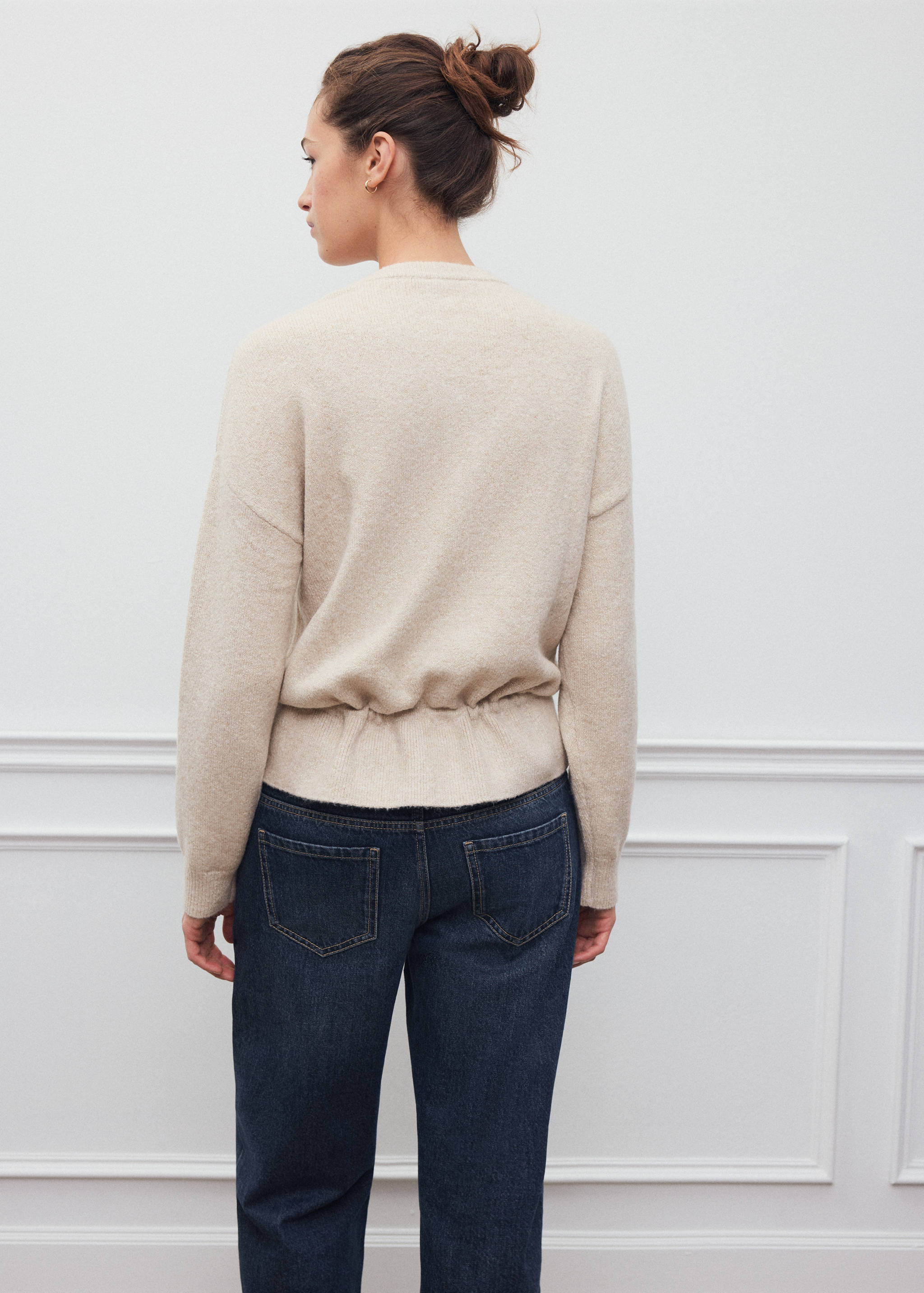 Beige knit jersey with an elasticated cinched waist, back view.