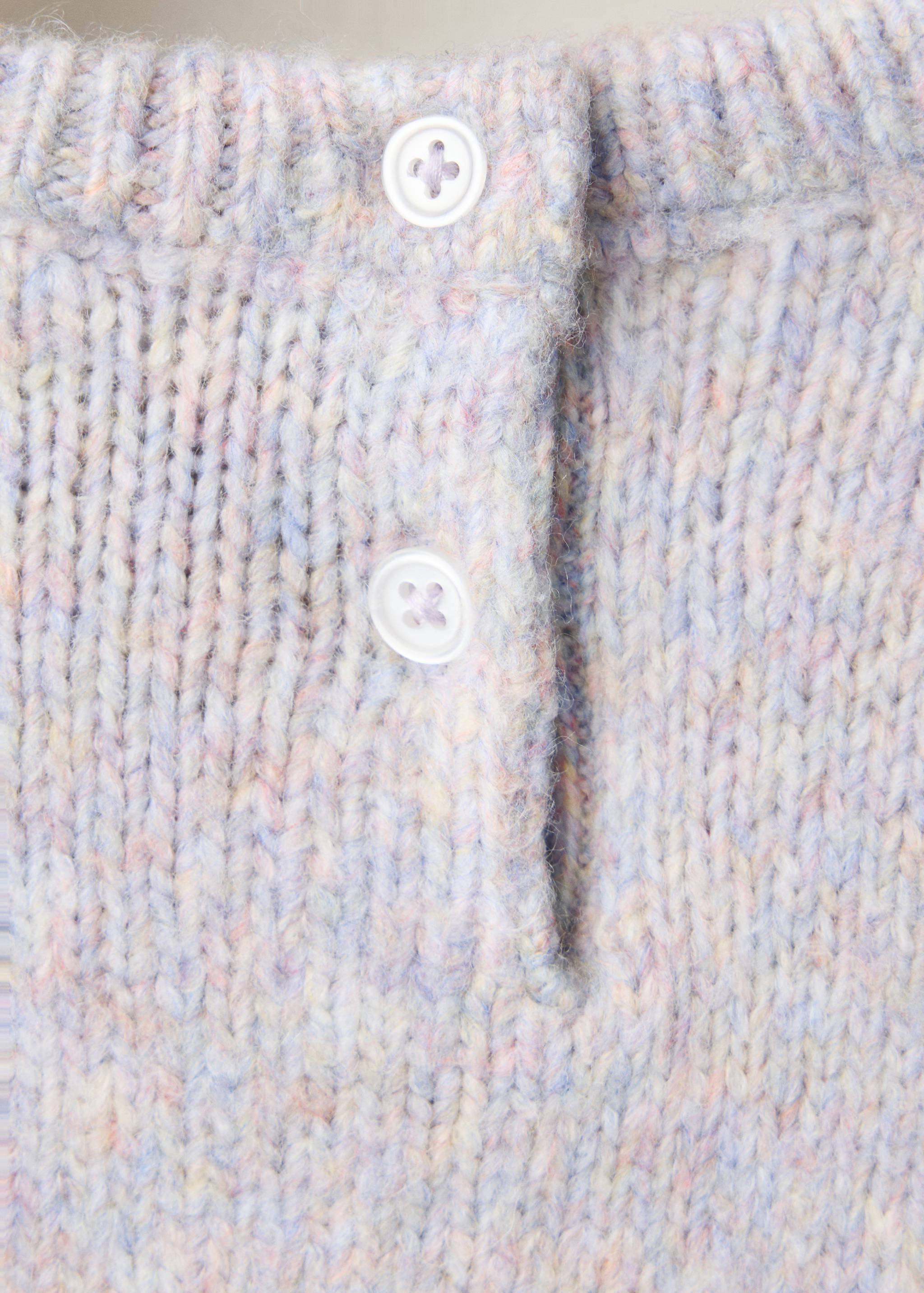 Close-up of a pastel knit jersey with a buttoned back neckline.