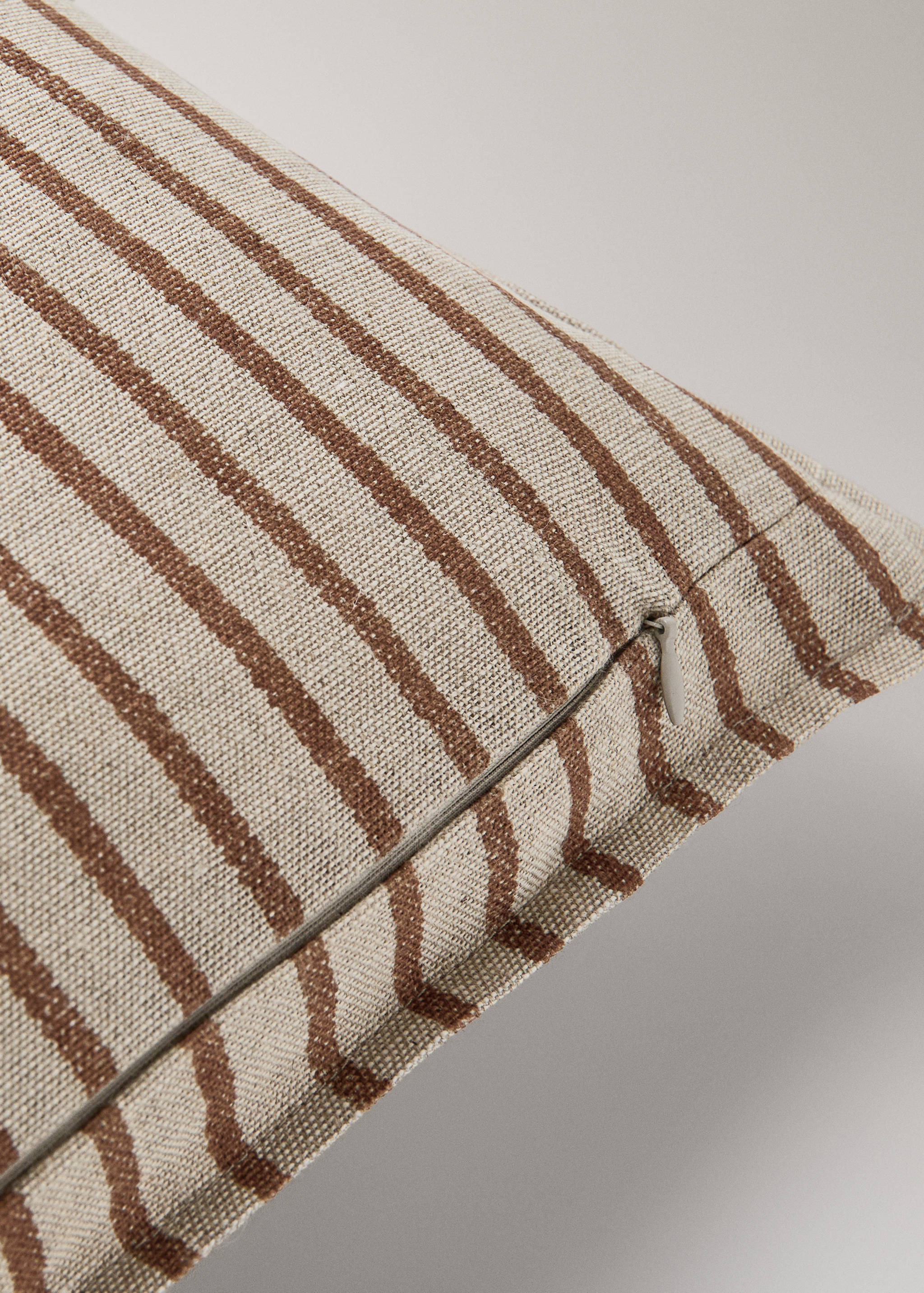 Brown and cream striped cushion cover detail with a concealed zip.