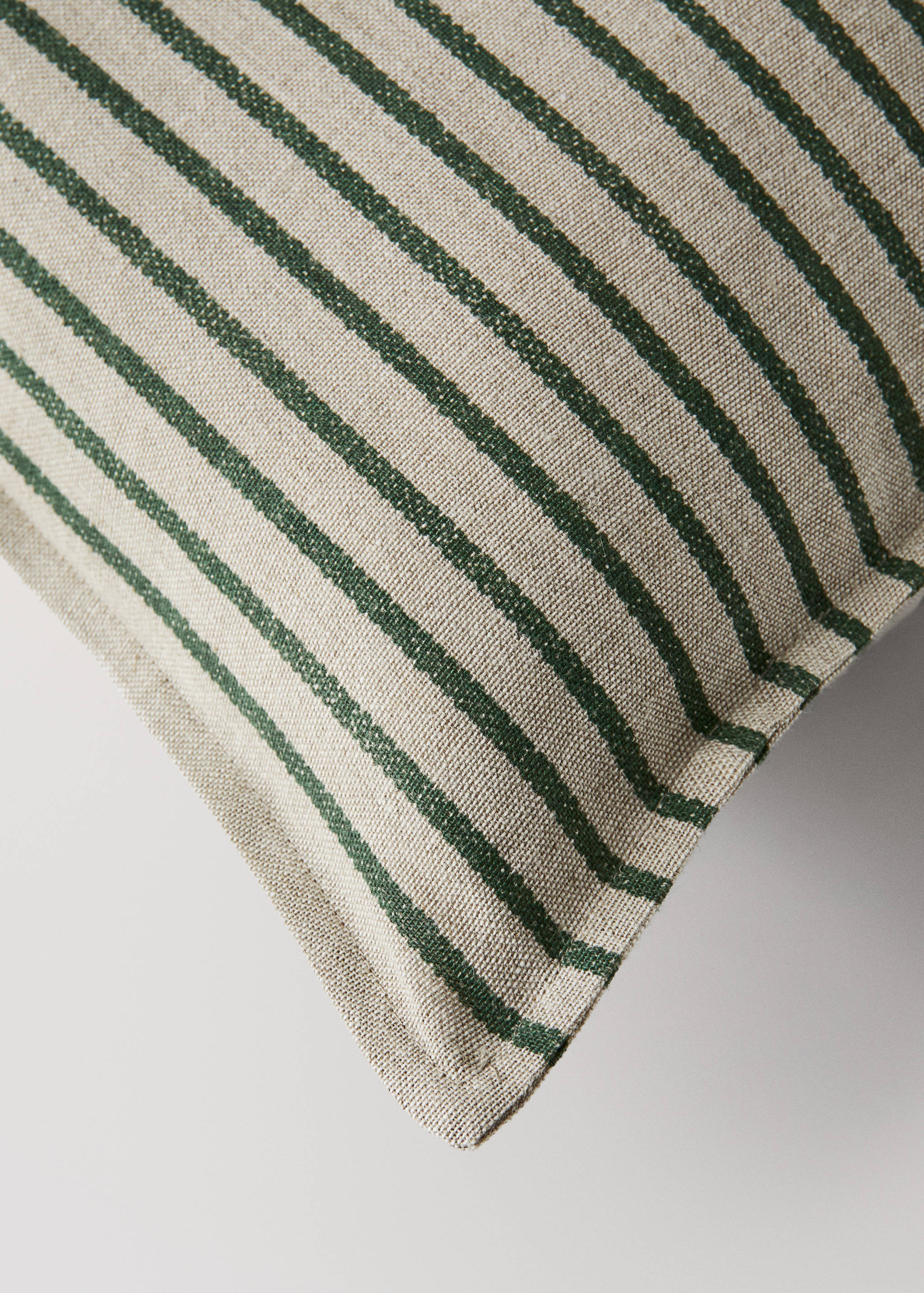 Green and beige striped cushion cover detail.