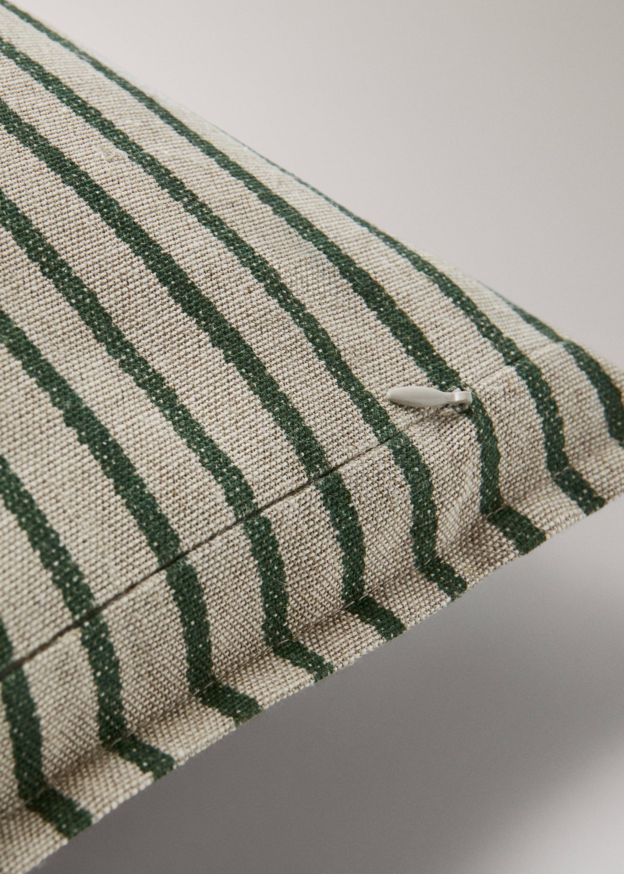 Close-up of a striped cushion cover detail with a concealed zip.