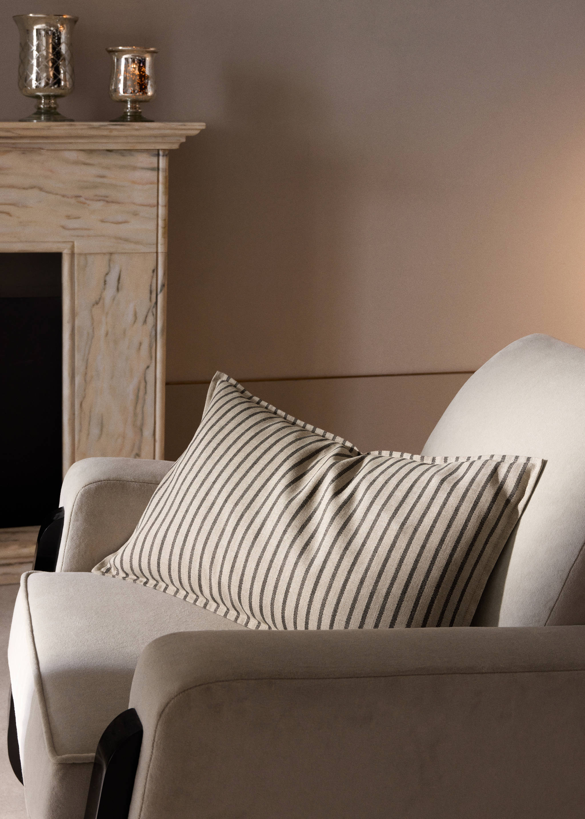 Rectangular cushion cover with vertical dark stripes on an armchair.