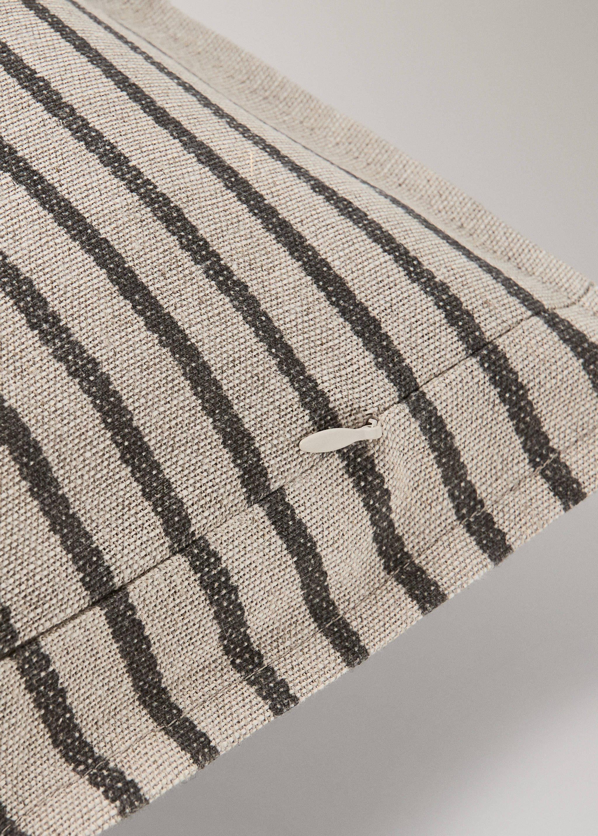 Striped cushion cover detail featuring a textured woven fabric and concealed zipper.