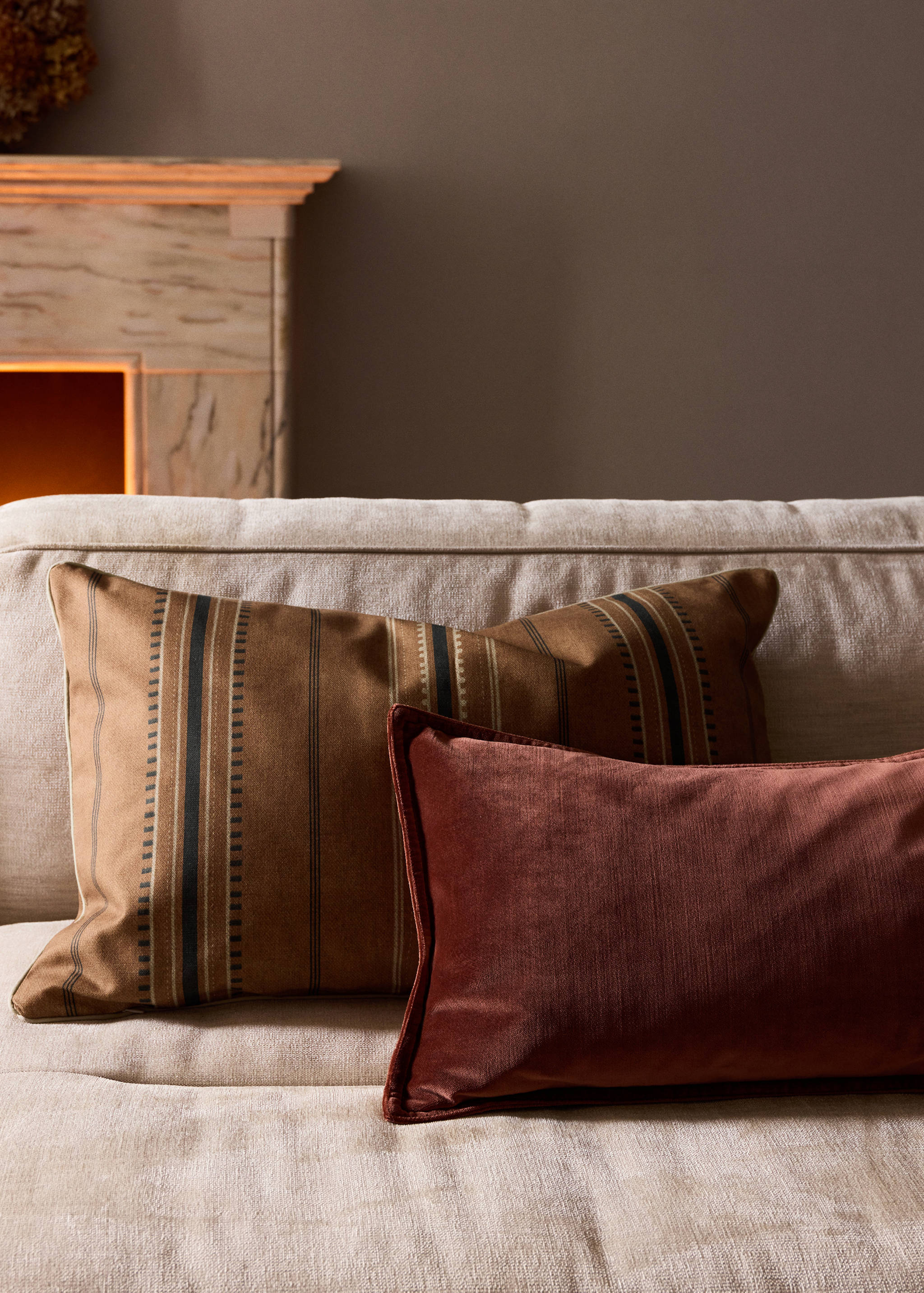 Terracotta red velvet cushion cover with a piped border.