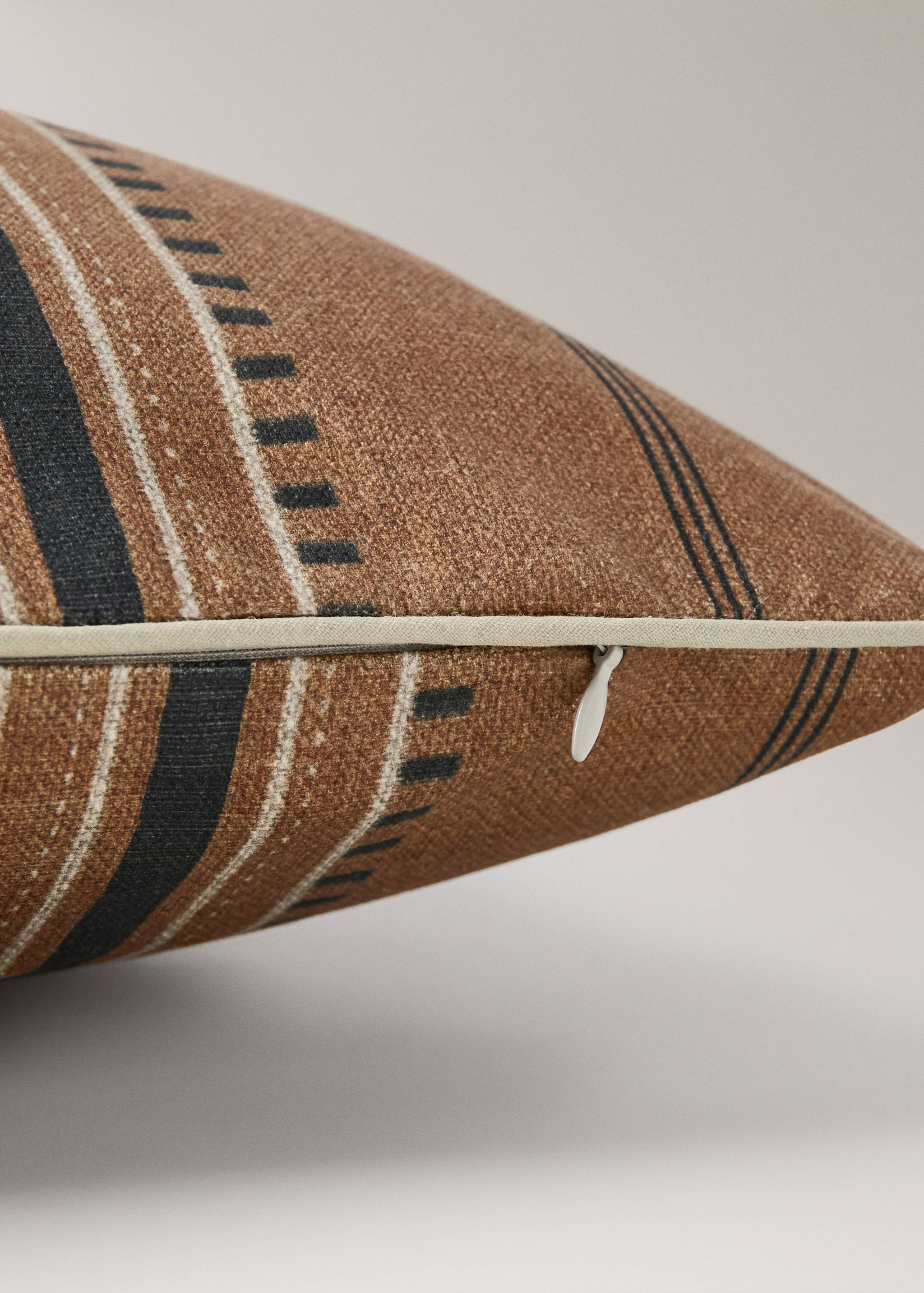 Brown patterned cushion cover detail showing the zipper closure.