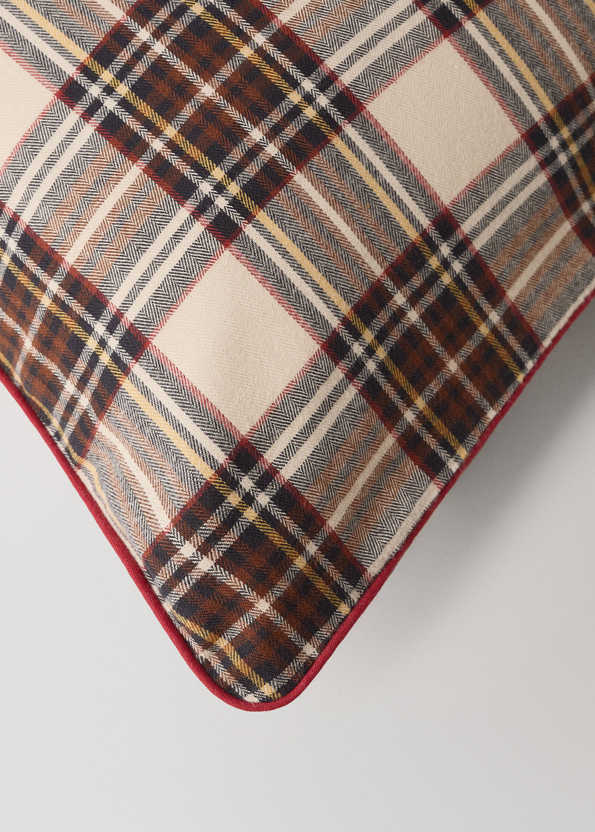 Plaid cushion cover with herringbone texture and red piping.
