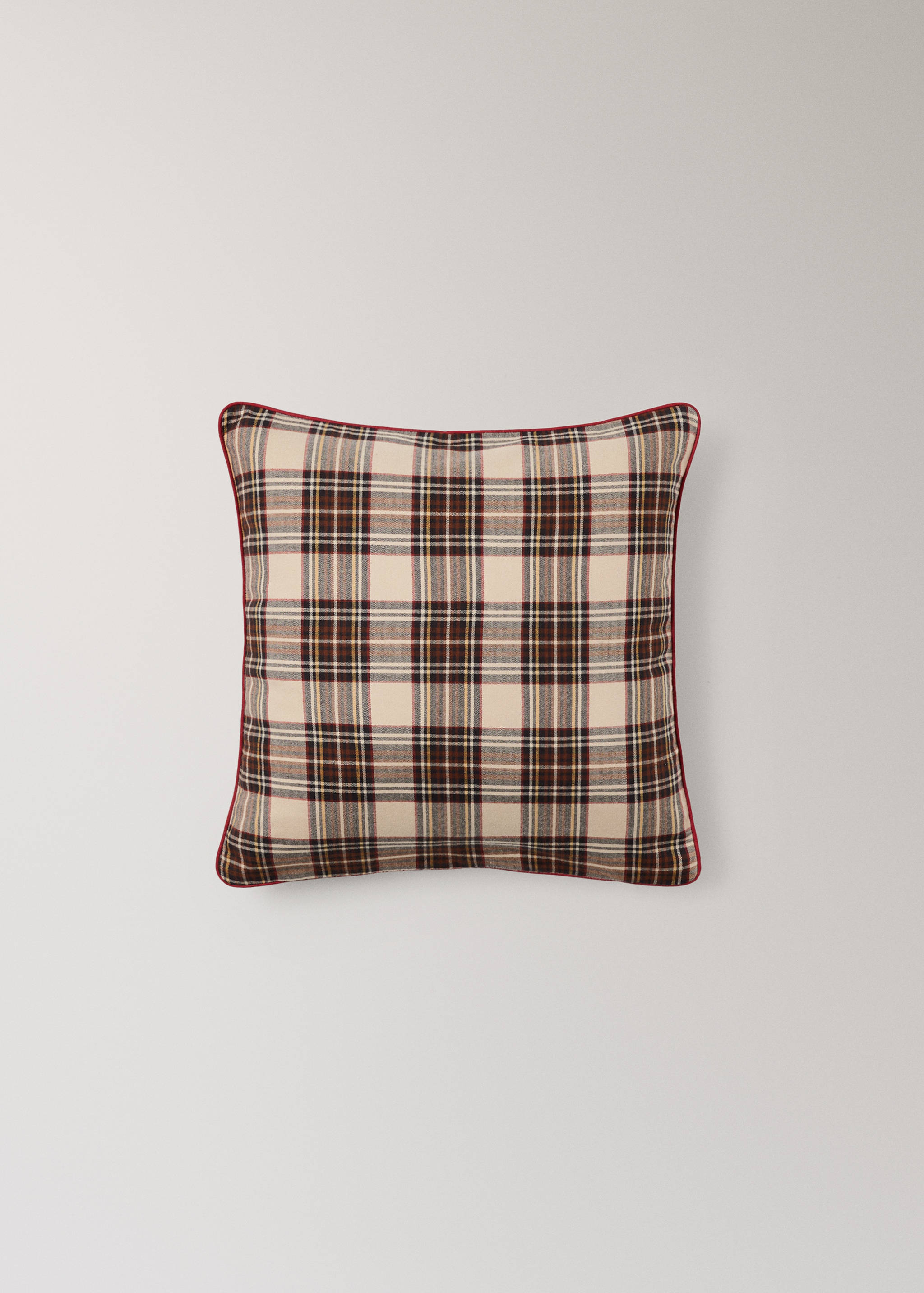 Cream and brown plaid cushion cover with red piping.