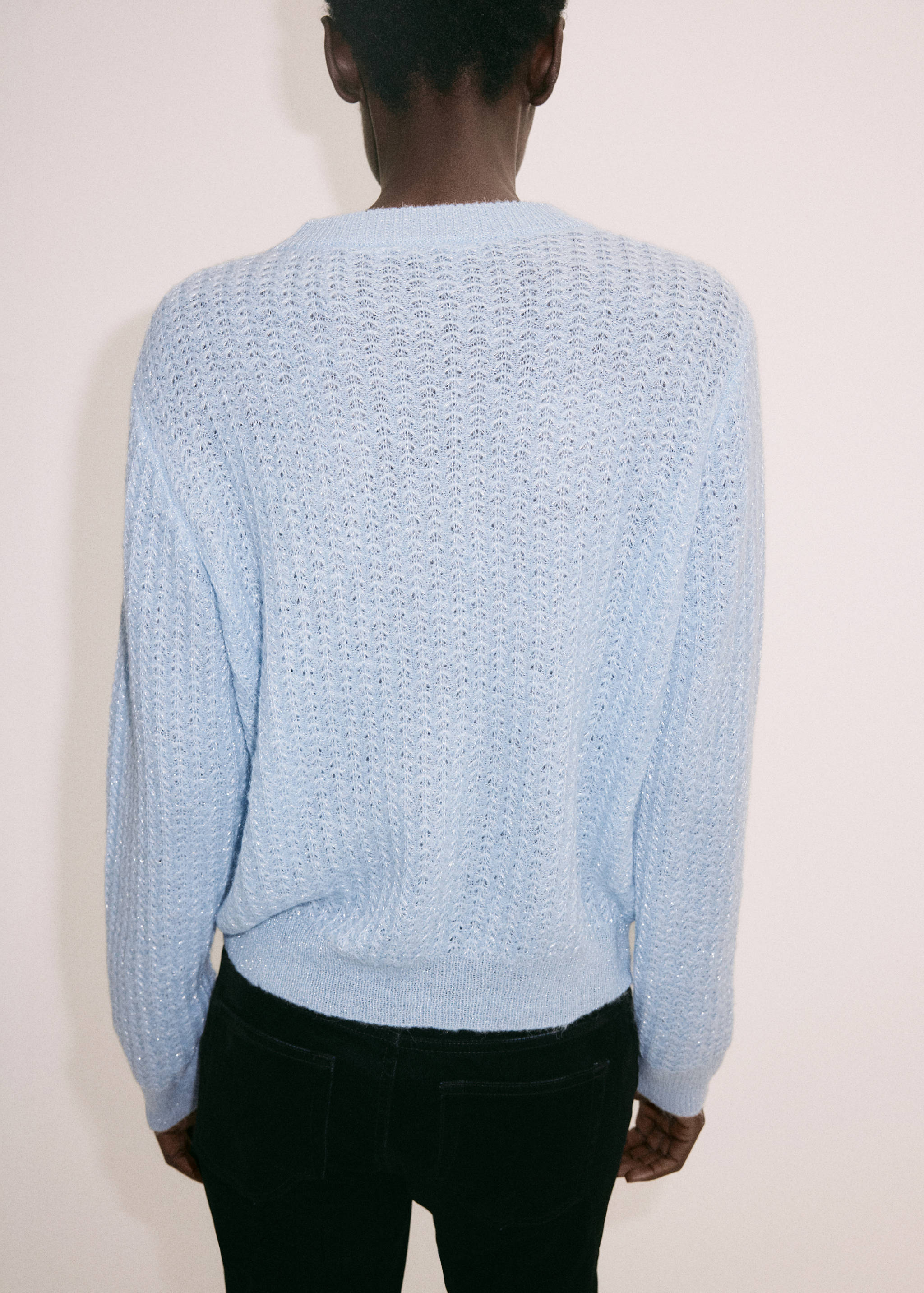 Light blue knitted jumper with a textured stitch pattern, back view.