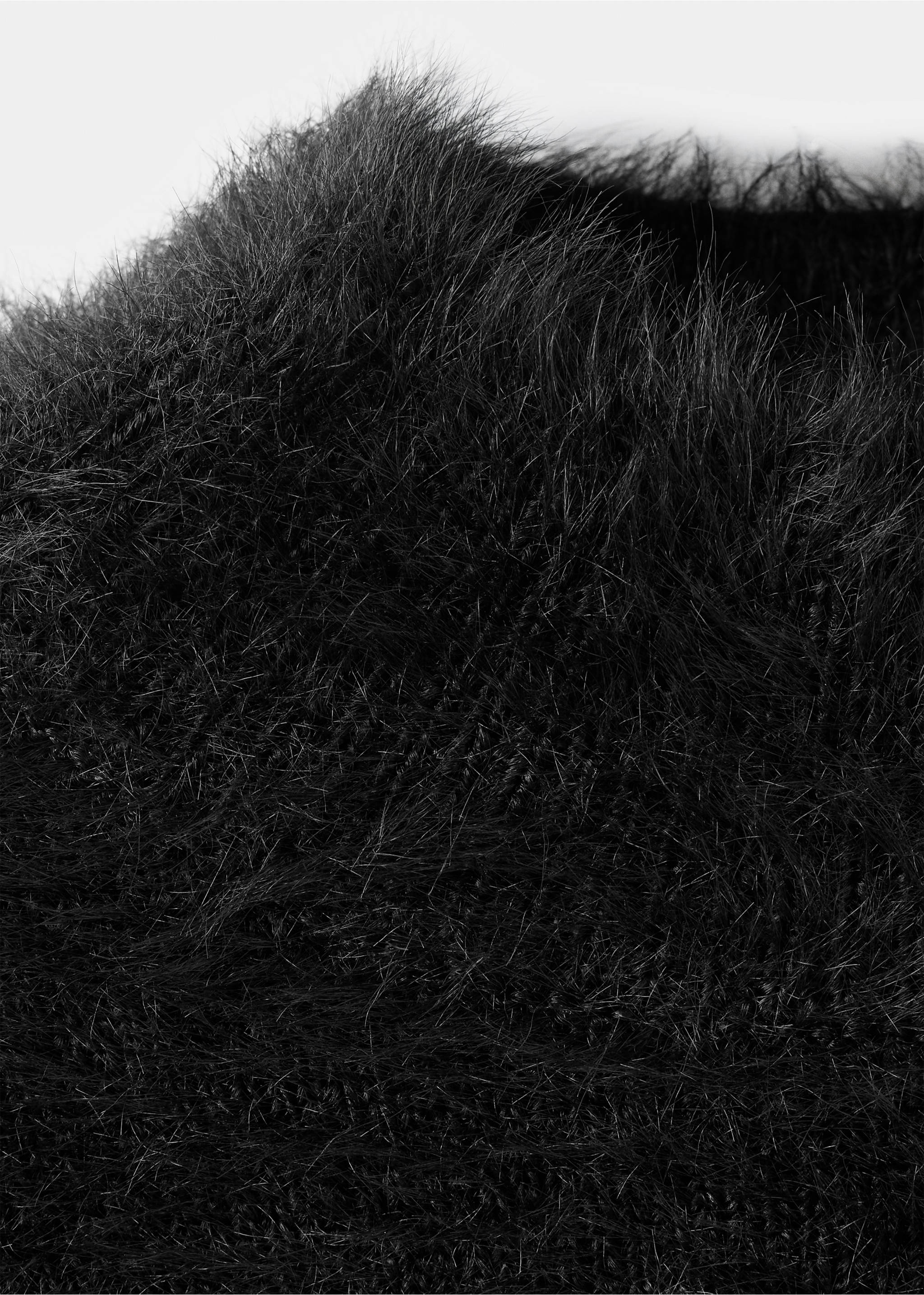 Close-up of a black fluffy jersey with a textured faux-fur finish., Black. Ref: 37009131-00.