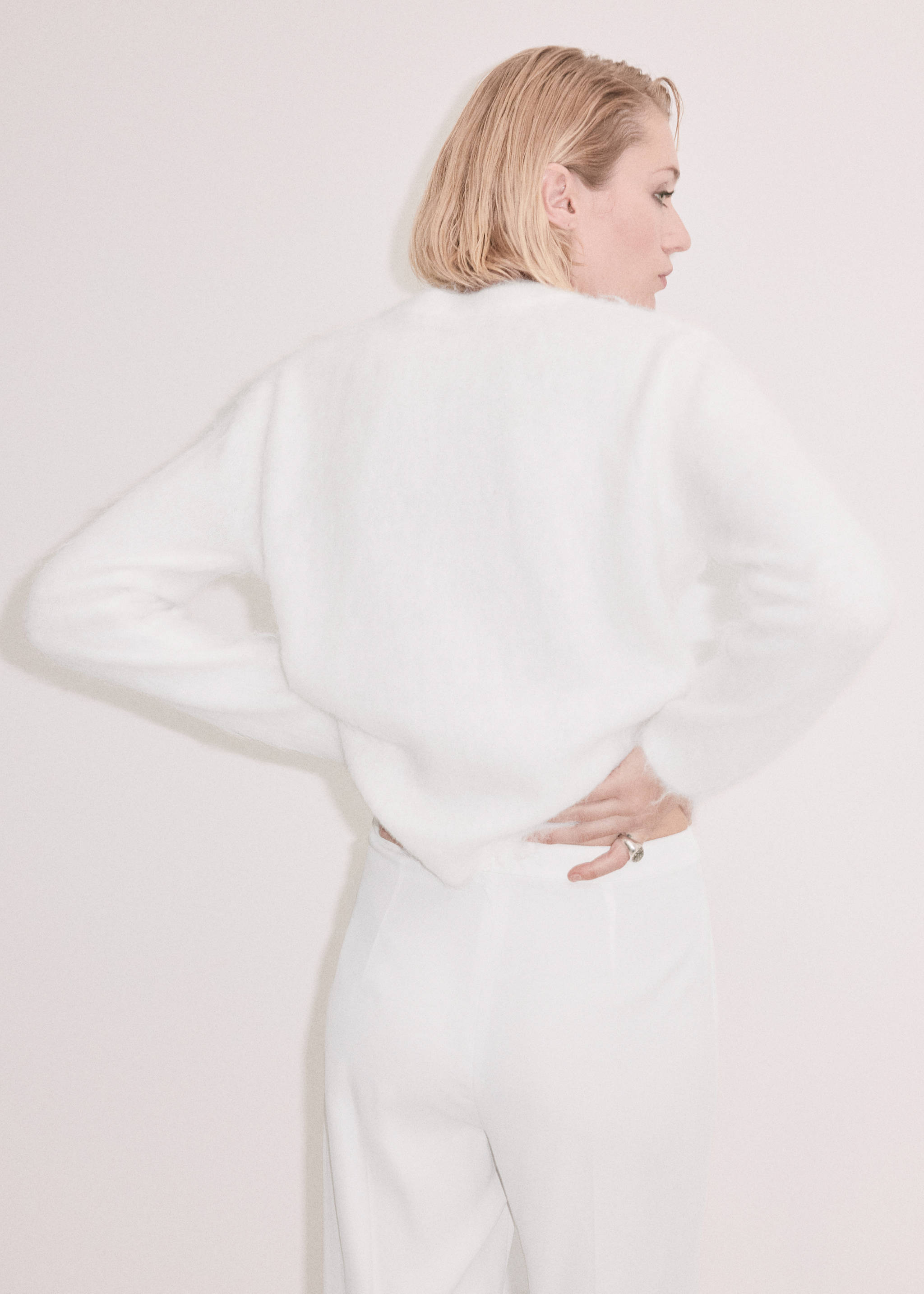 Back view of a white fuzzy knit jersey with long sleeves.