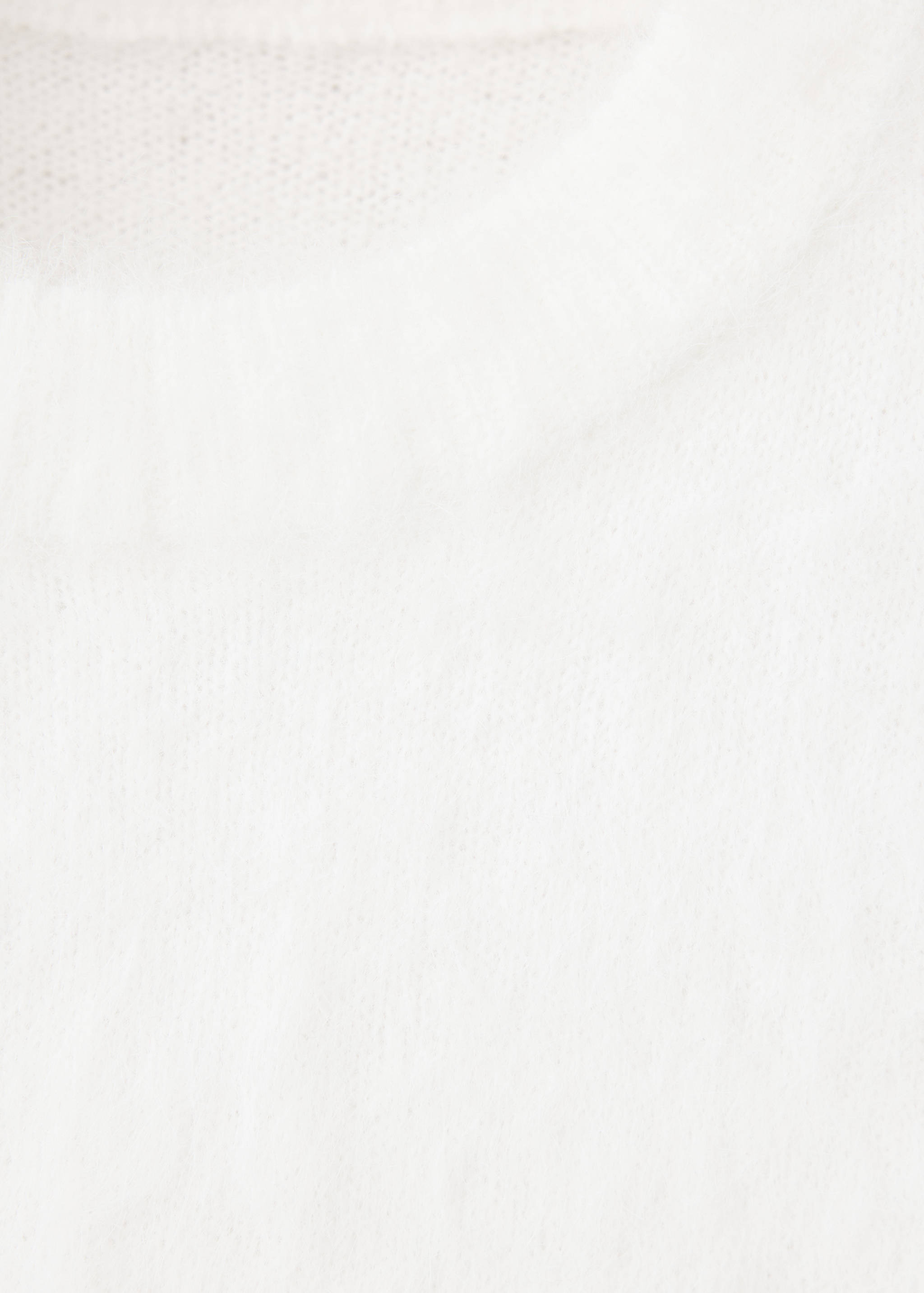 Close-up of the neckline and textured knit of a white jersey.