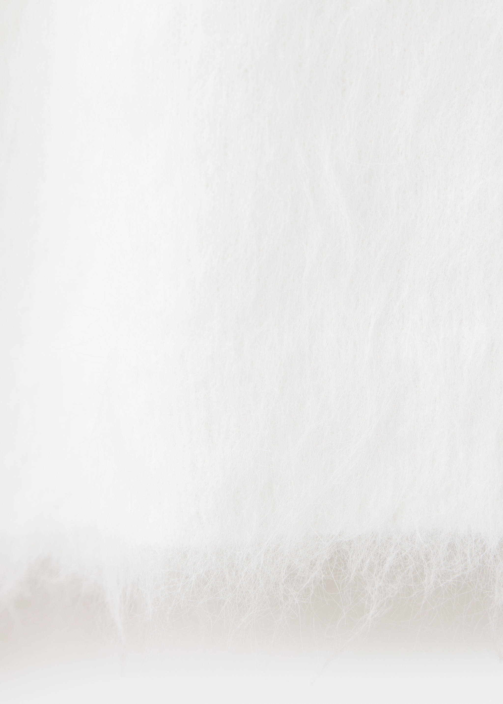Close-up of the white fluffy knit fabric of a jersey.