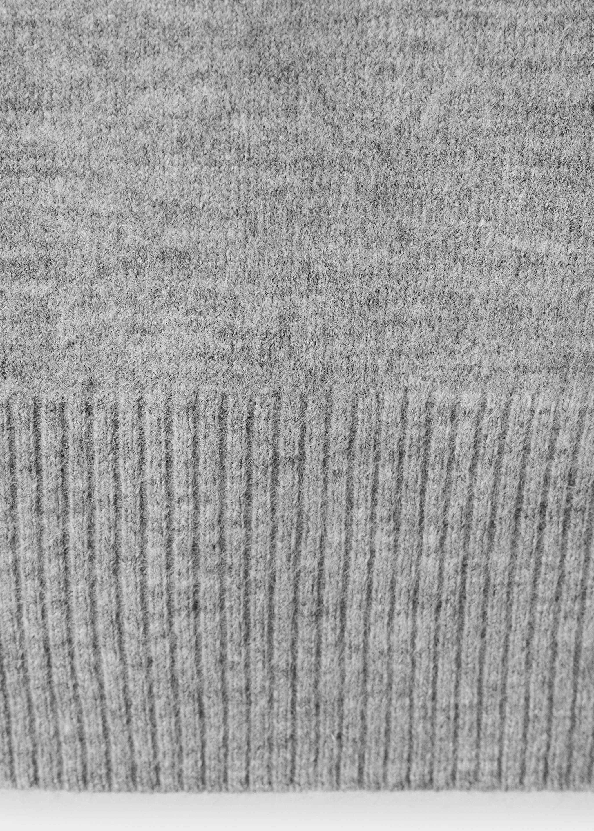 Close-up of a grey knit jersey fabric texture showing the ribbed hem.