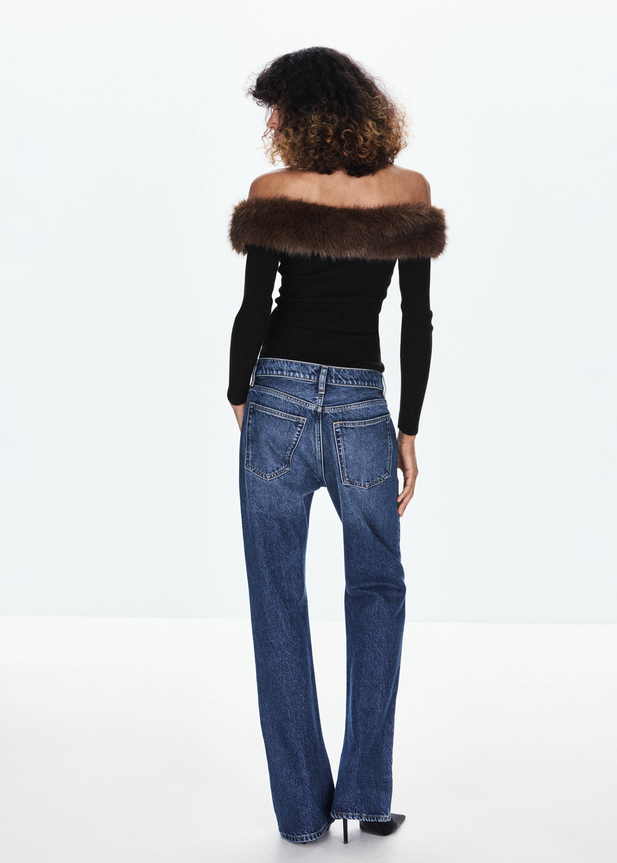 Back view of a black off-the-shoulder jersey with brown faux-fur trim.