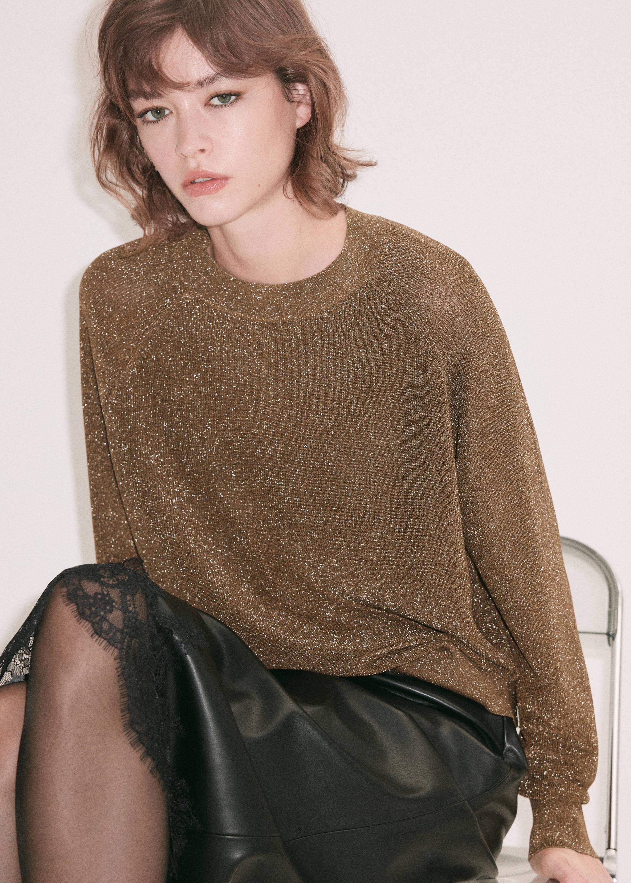 Metallic gold knit jersey with a round neckline and long sleeves.