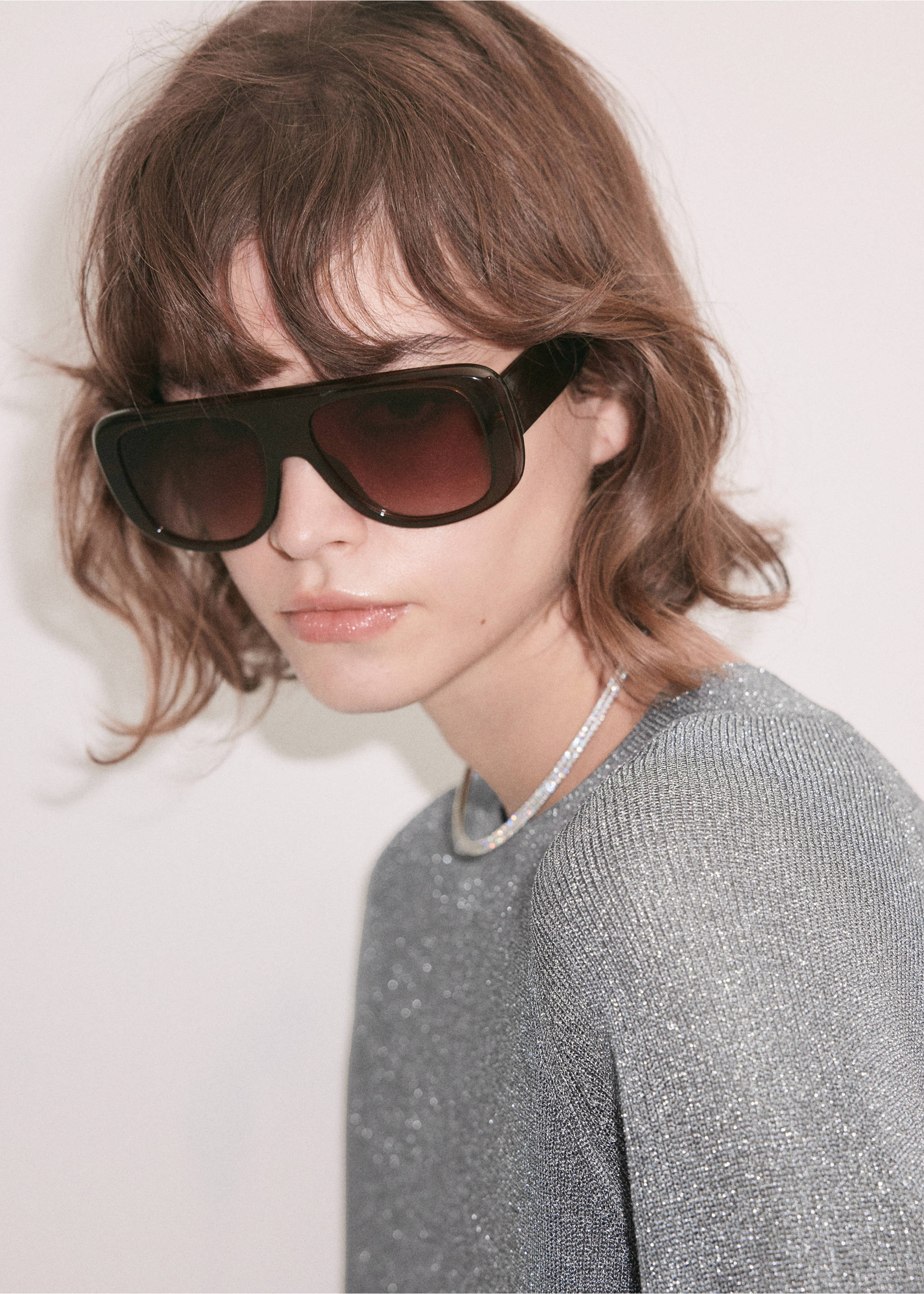 Silver knitted jersey with a round neckline, shown in a close-up portrait with sunglasses., Silver. Ref: 37009140-00.