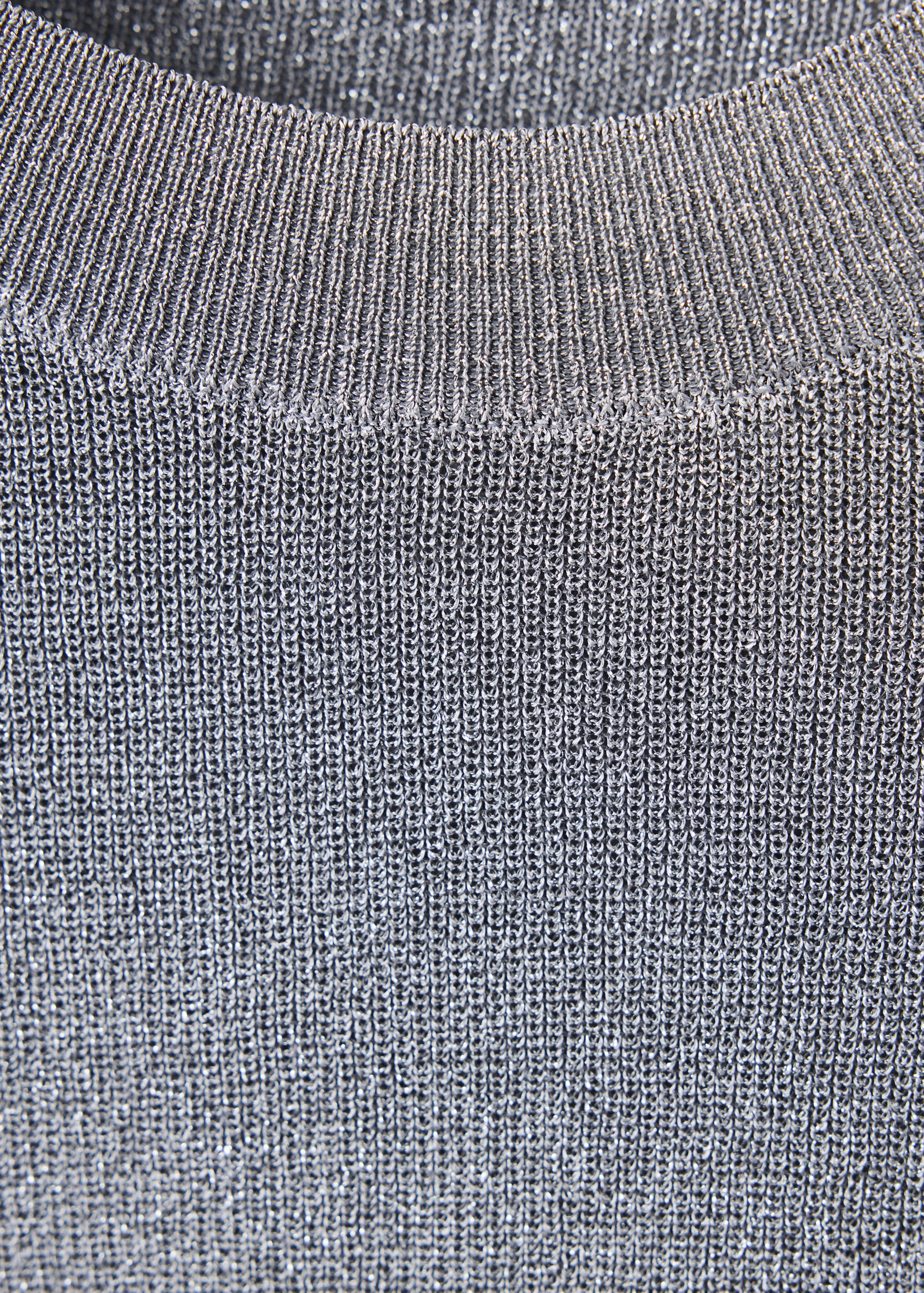 Close-up of a metallic silver knit jersey sweater showing the ribbed neckline.