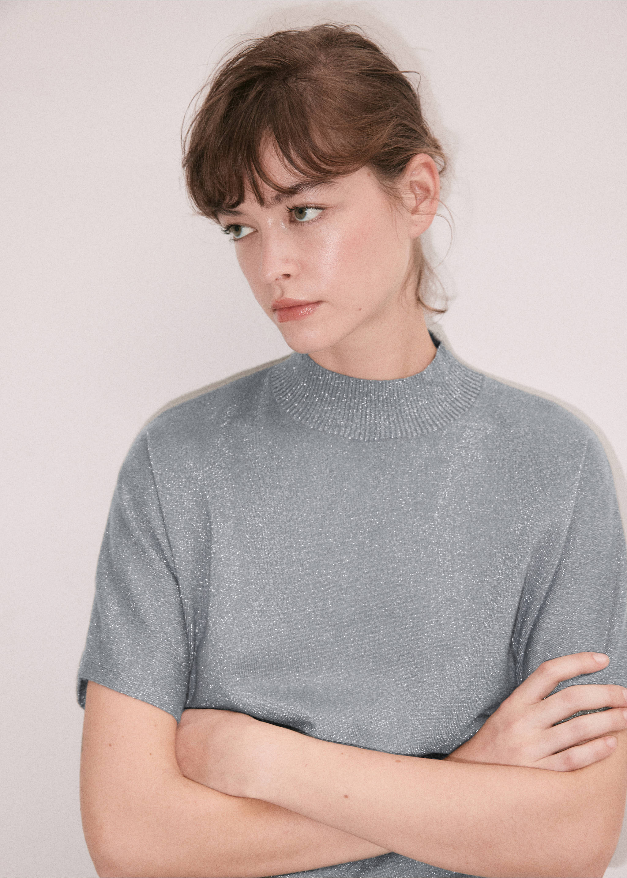 Grey metallic short-sleeve jersey with a ribbed high neck, shown in a close-up., Silver. Ref: 37009141-00.