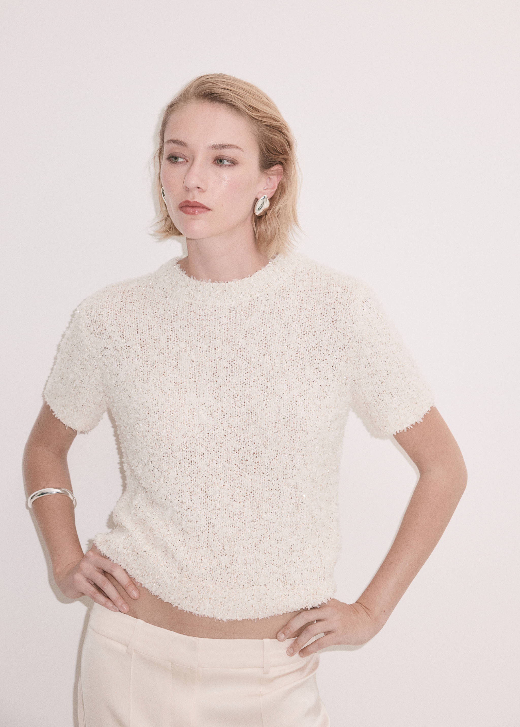 Jersey blanco de manga corta con textura y cuello redondo.