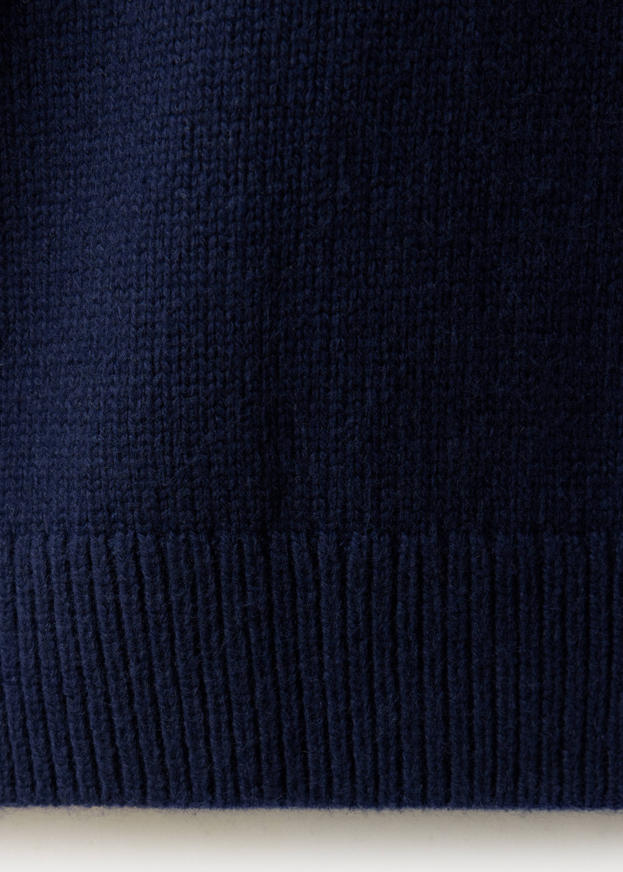 Dark navy blue jumper fabric texture detail showing a fine knit and ribbed hem.