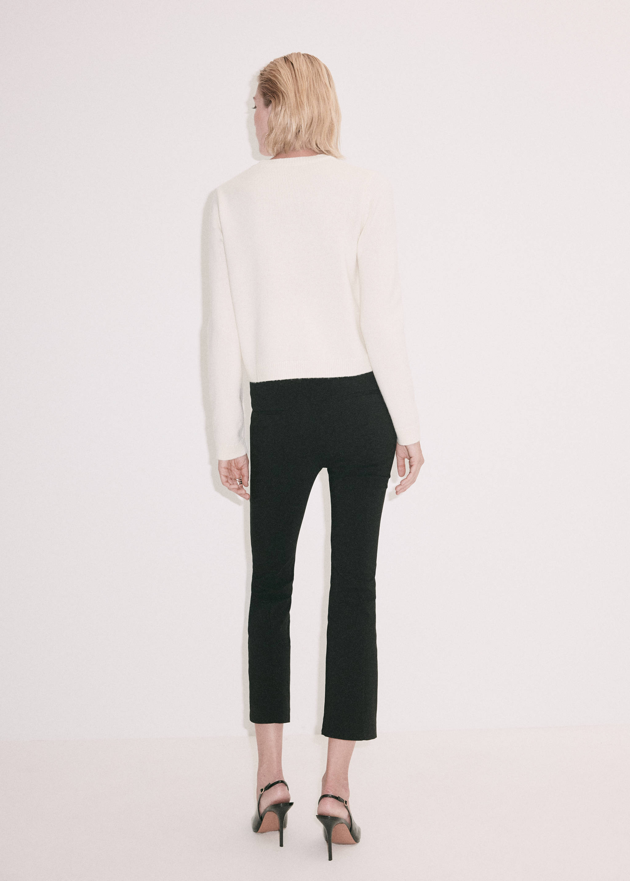 Back view of a cream white knit jumper with a round neckline and long sleeves.