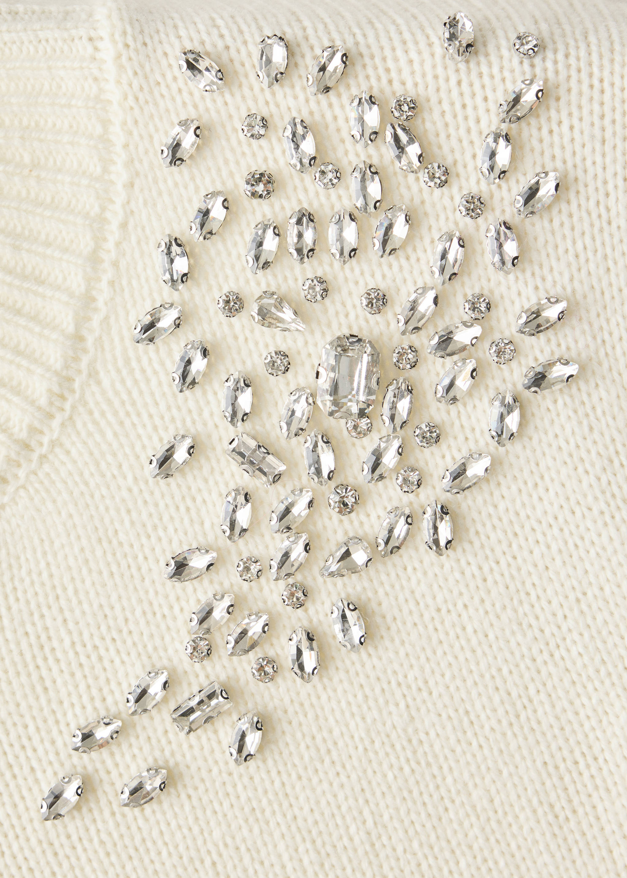 Close-up of an off-white jersey with crystal rhinestone embellishments.