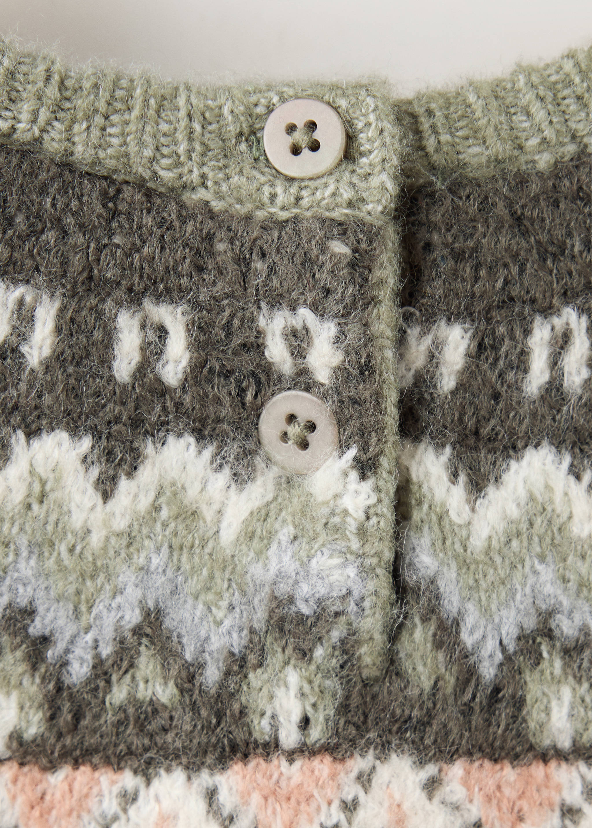 Close-up of the back button placket and patterned knit on a kids' multi-coloured sweater.