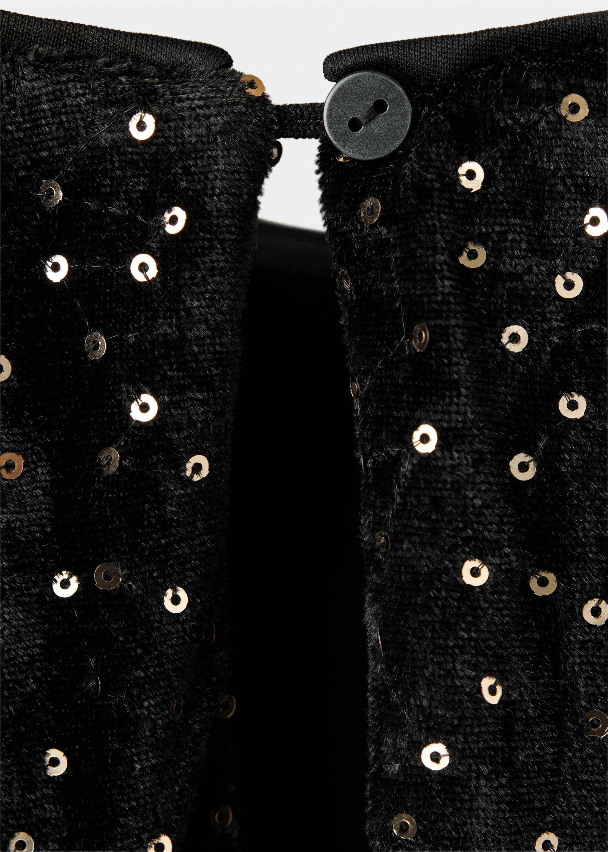 Close-up of a black sequinned kids' T-shirt fabric showing the back button-and-loop closure., Black. Ref: 37009213-00.