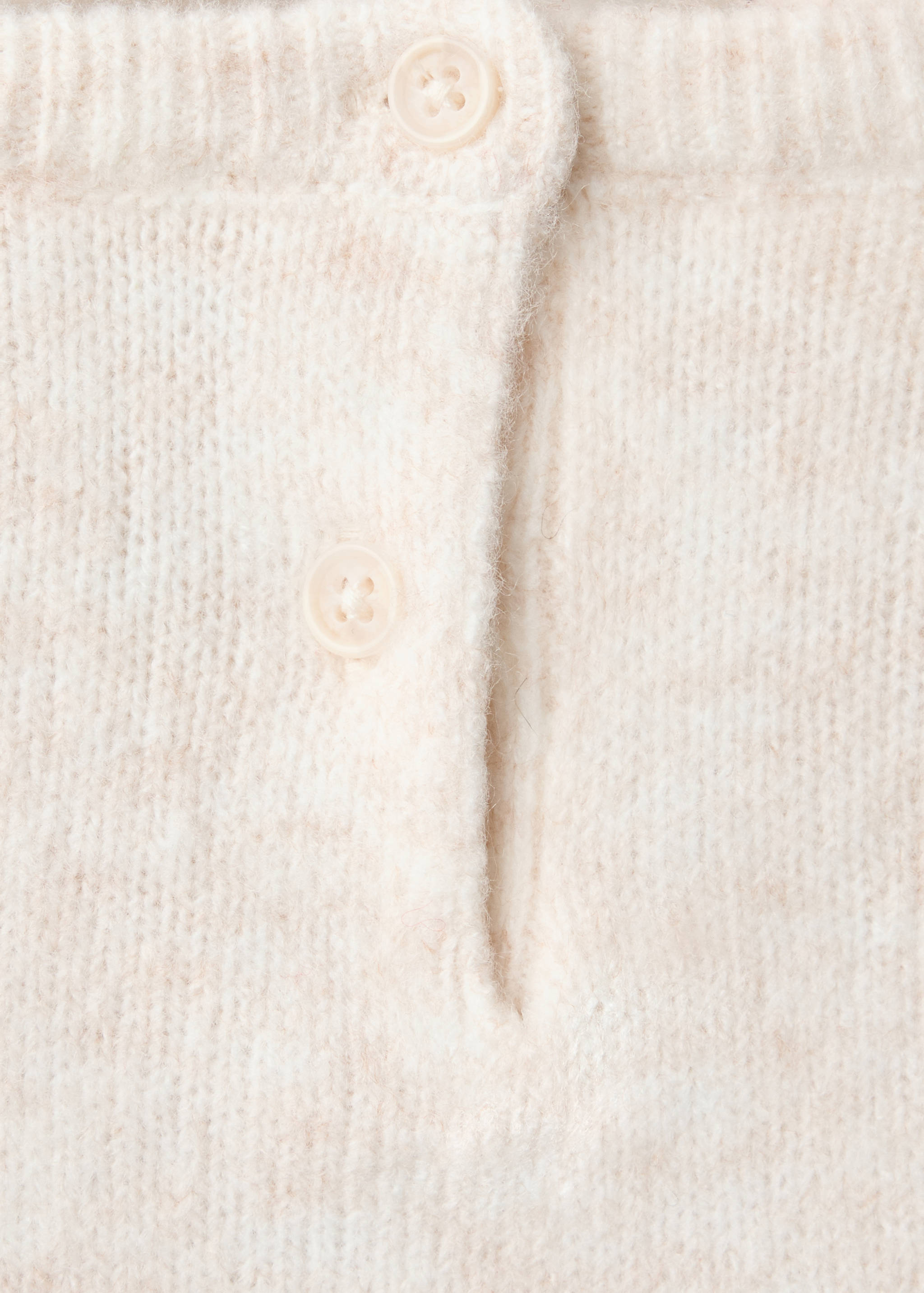 Cream knitted jersey fabric and button detail.