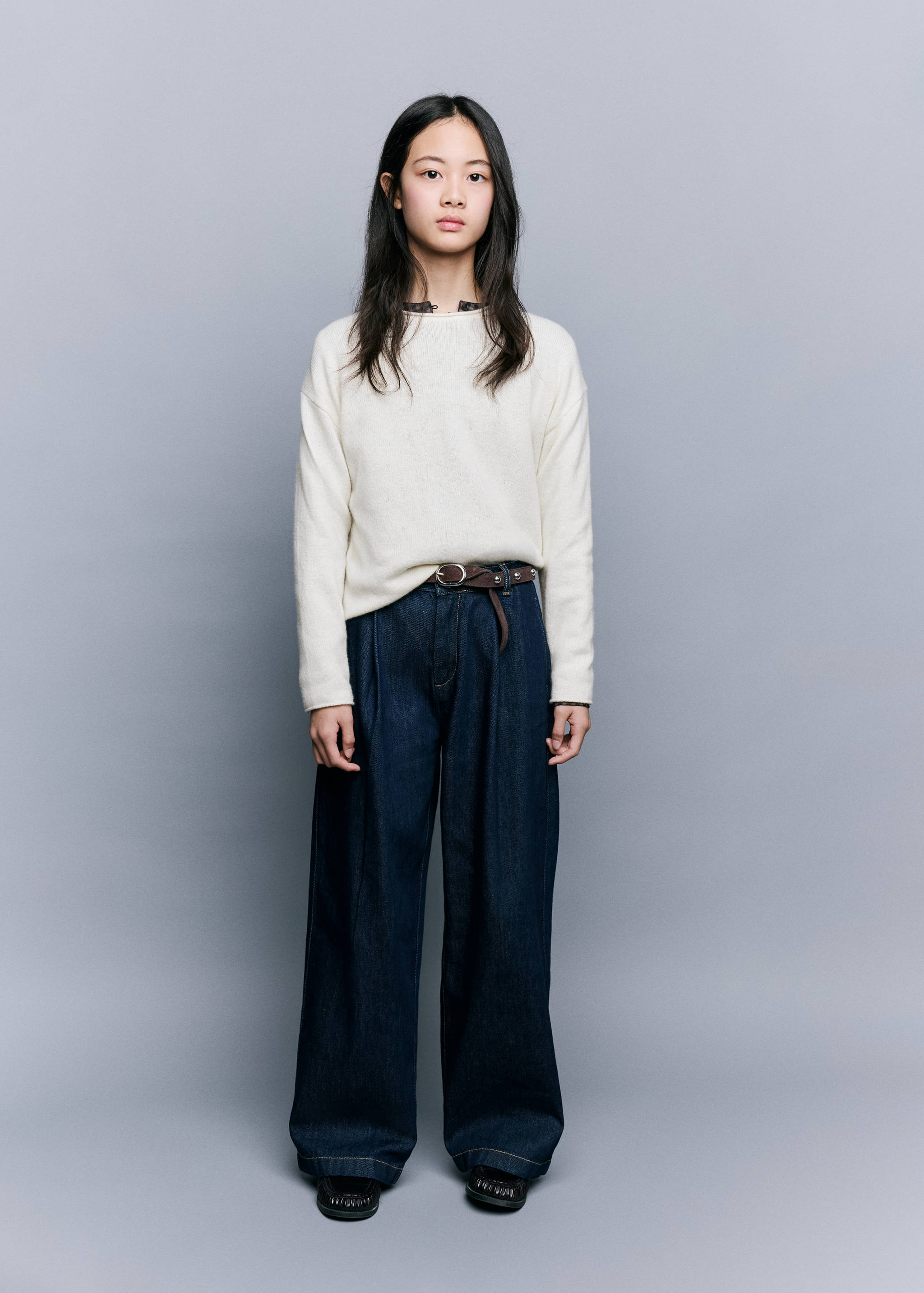 White long-sleeved fine-knit jersey paired with dark wide-leg trousers.