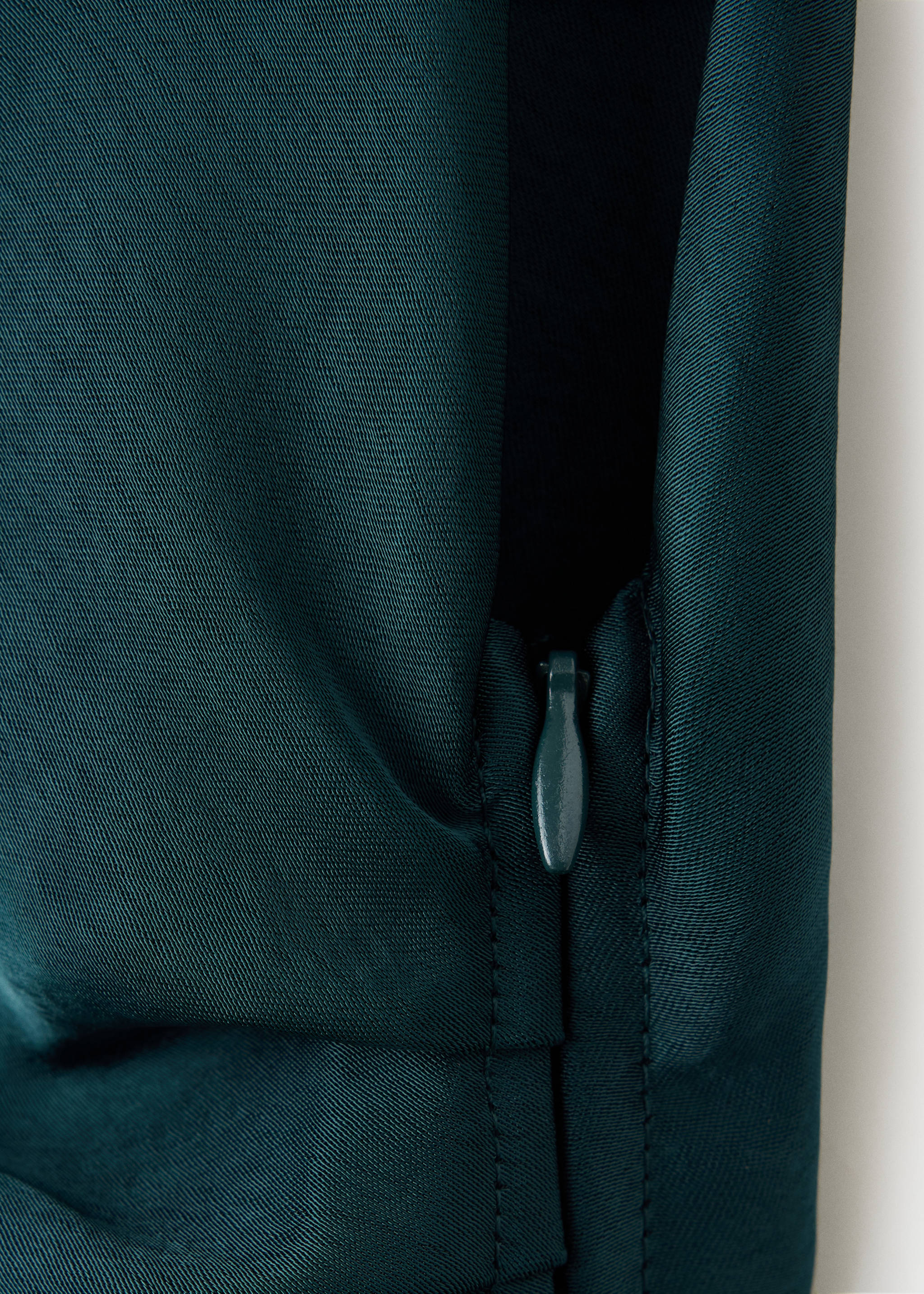 Dark green dress detail showing the side zip closure.