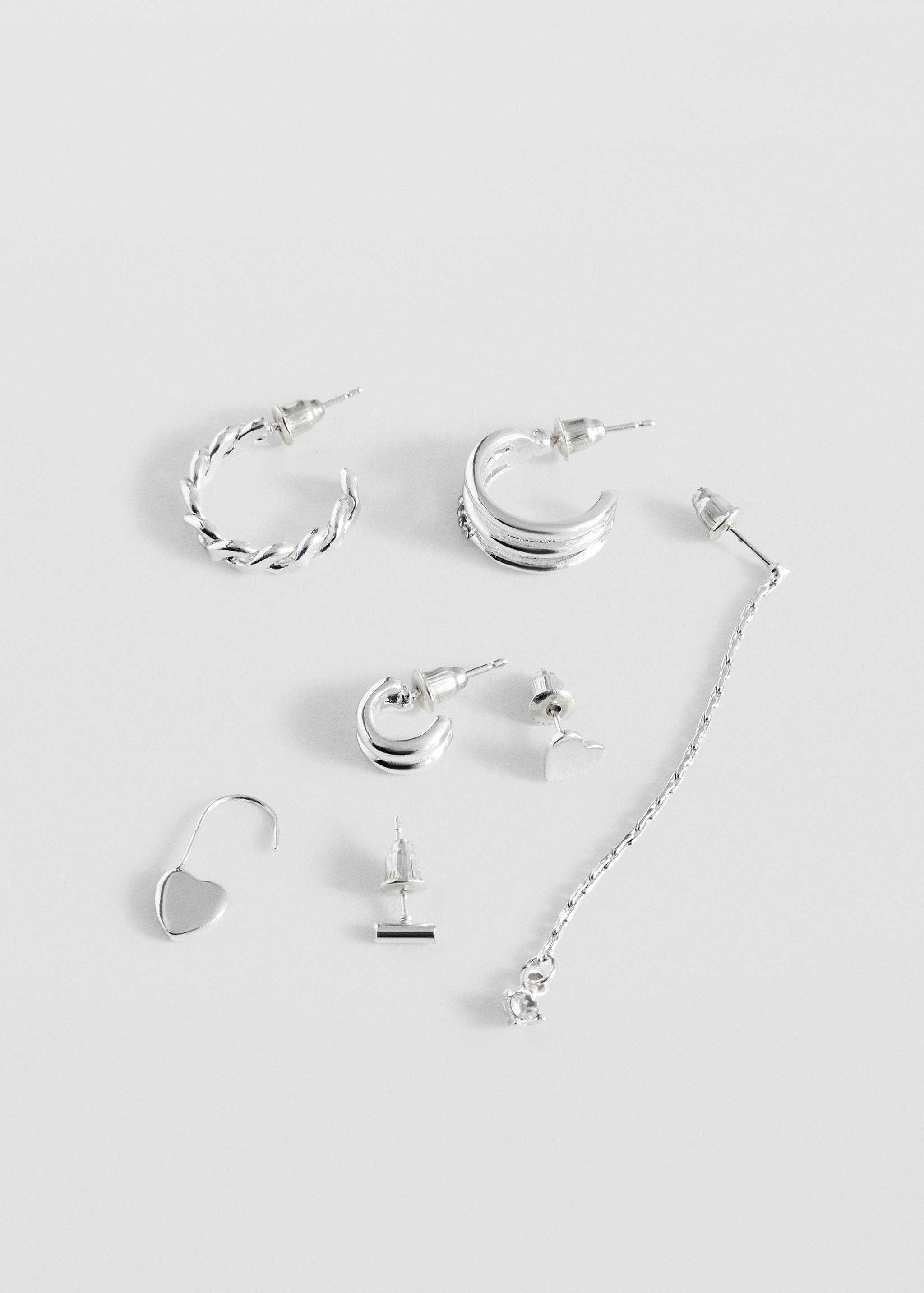 Set of silver-coloured earrings in mixed hoop, stud, and drop designs.