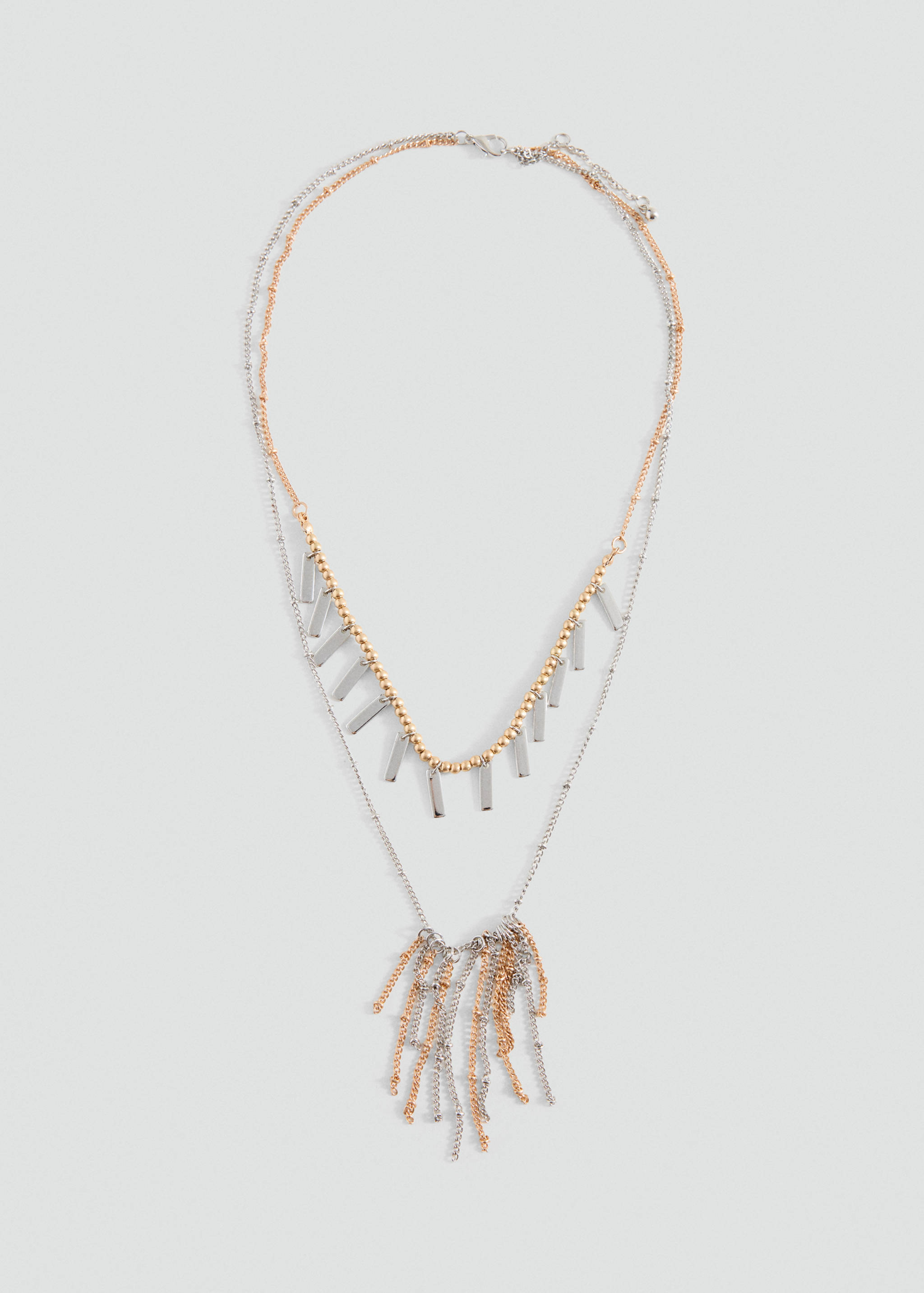 Layered multi-strand necklace in silver and gold with charms and pendant.