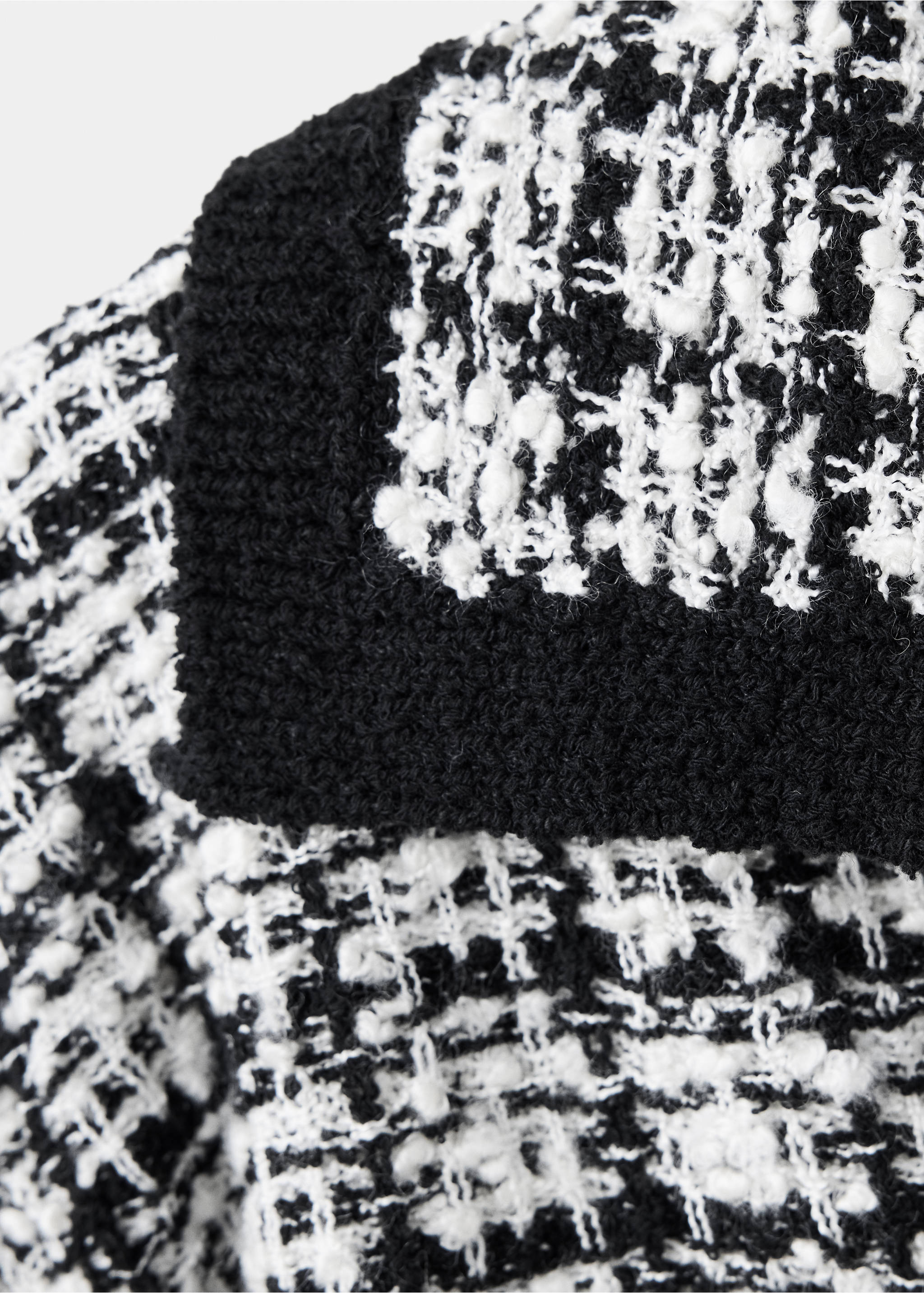 Close-up of the black and white checked knit fabric and ribbed hem of a jumper., Black. Ref: 37015892-00.