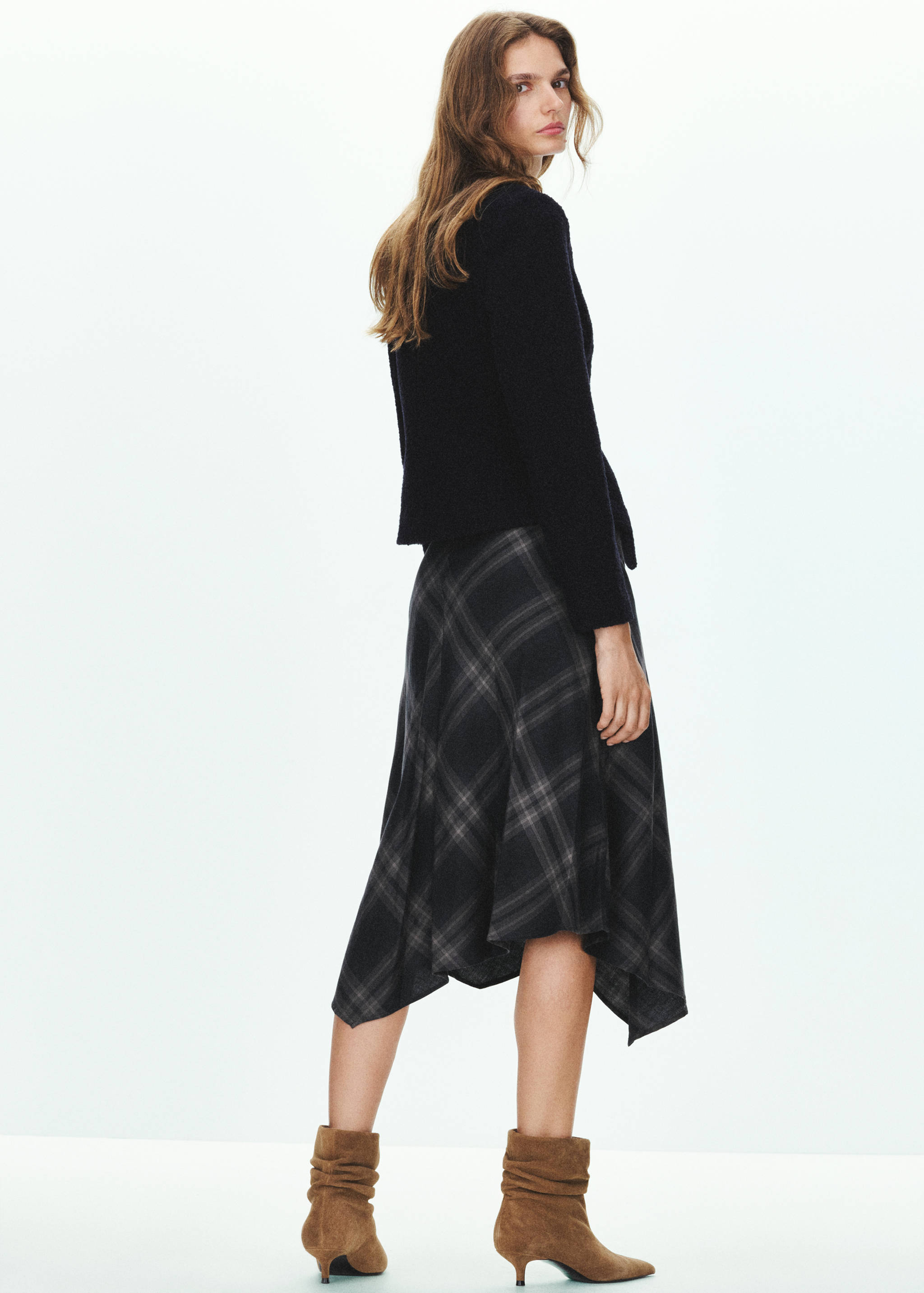 Black and grey plaid midi skirt with an asymmetric hem, back view.