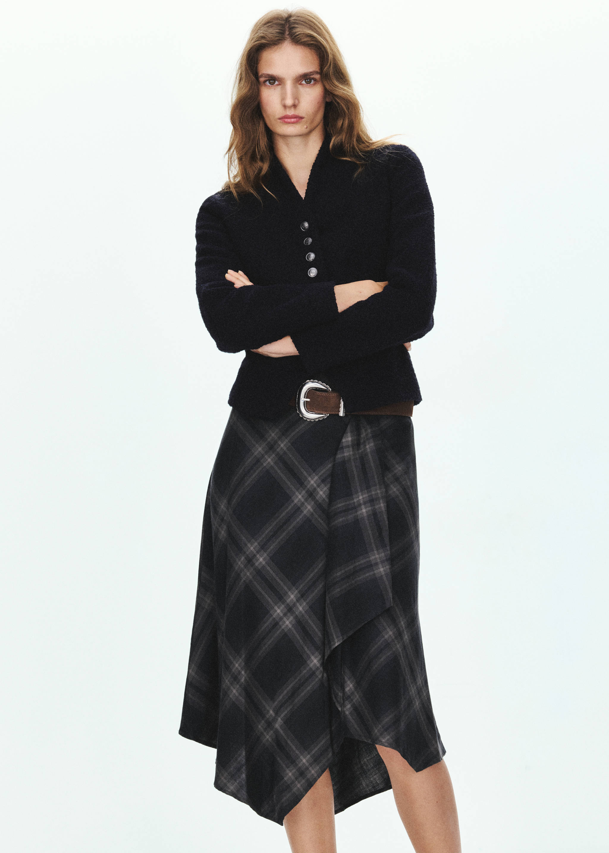 Plaid midi skirt in dark grey, worn with a black textured jacket.