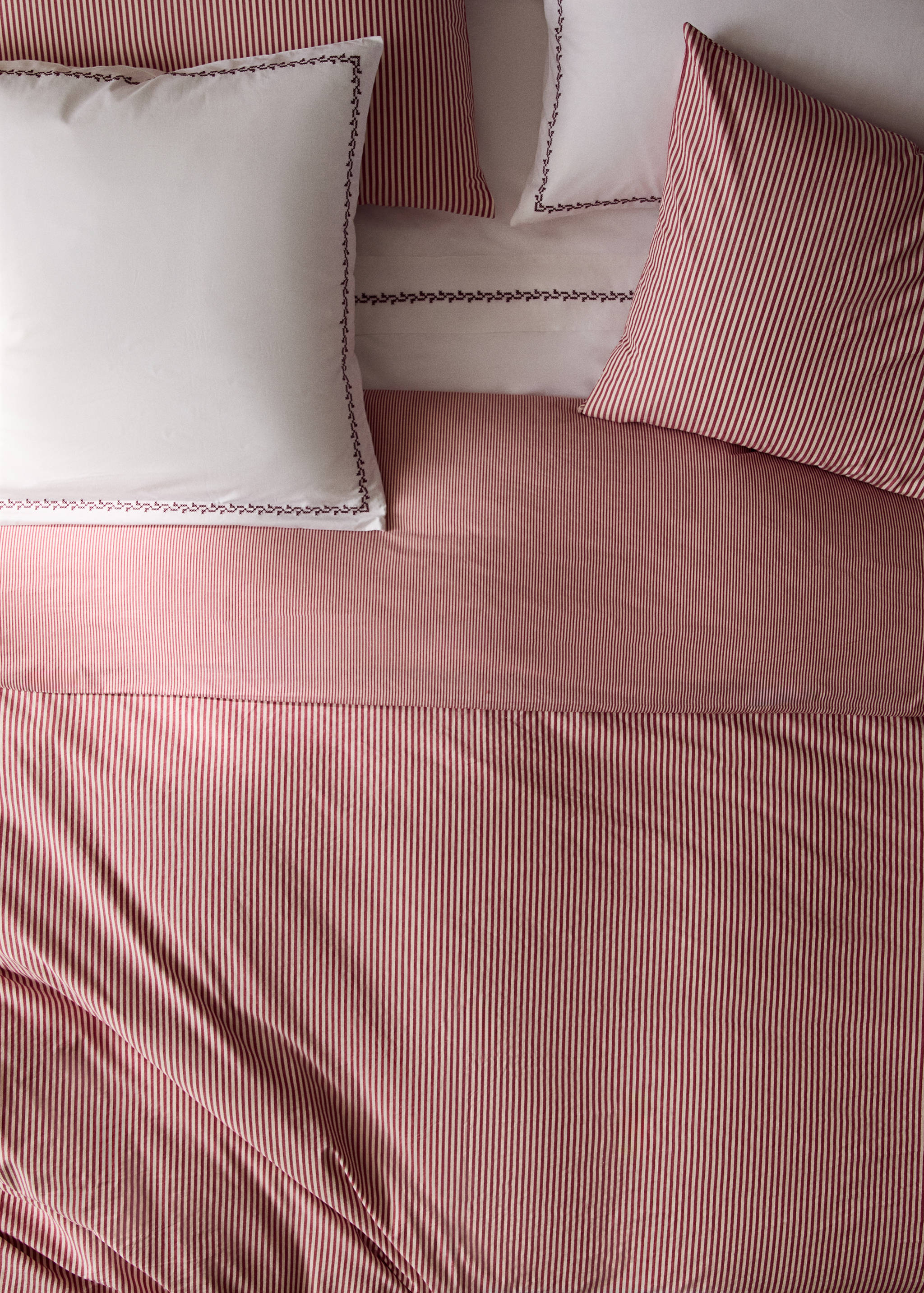 Red and white striped duvet cover on a made bed with matching pillows.