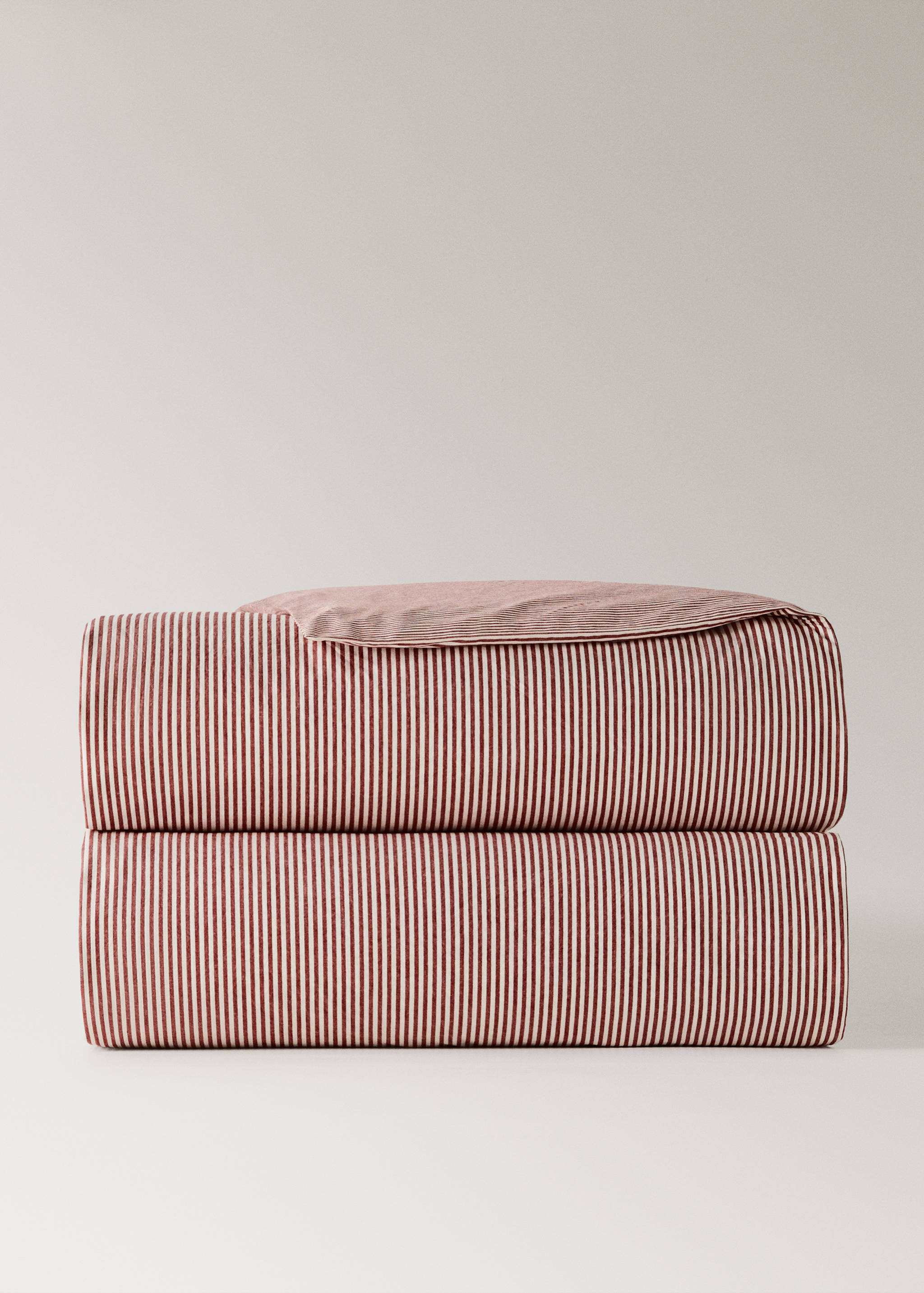Red and white striped duvet cover folded in a neat stack.