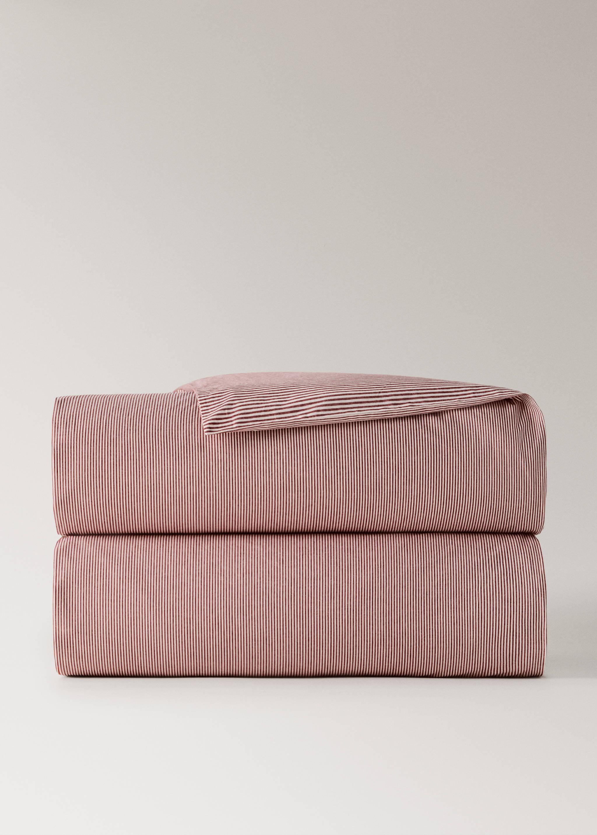 Red and white striped duvet cover in a still-life stack.