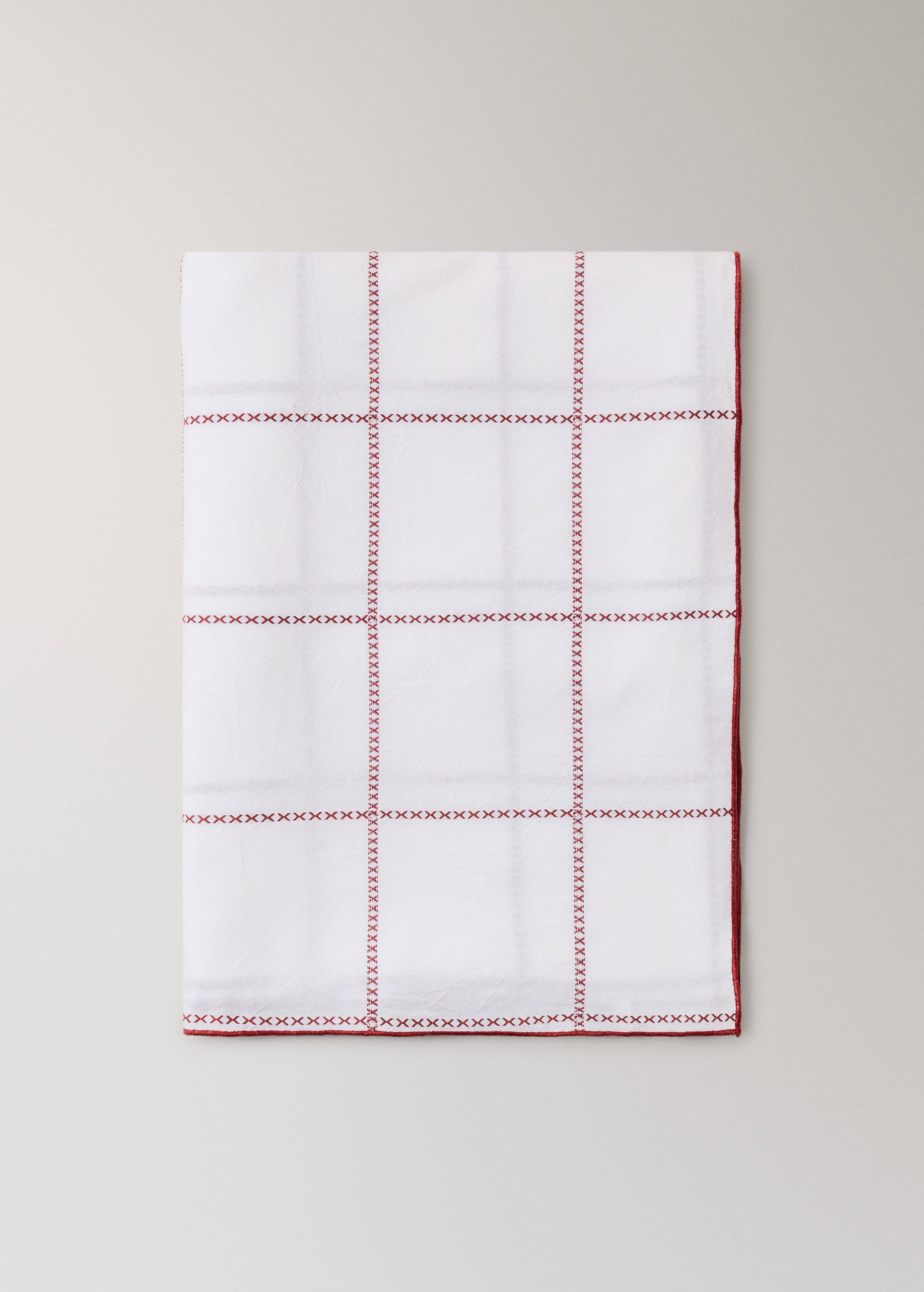 Mantel blanco con cuadrícula y cenefa de punto de cruz en rojo.