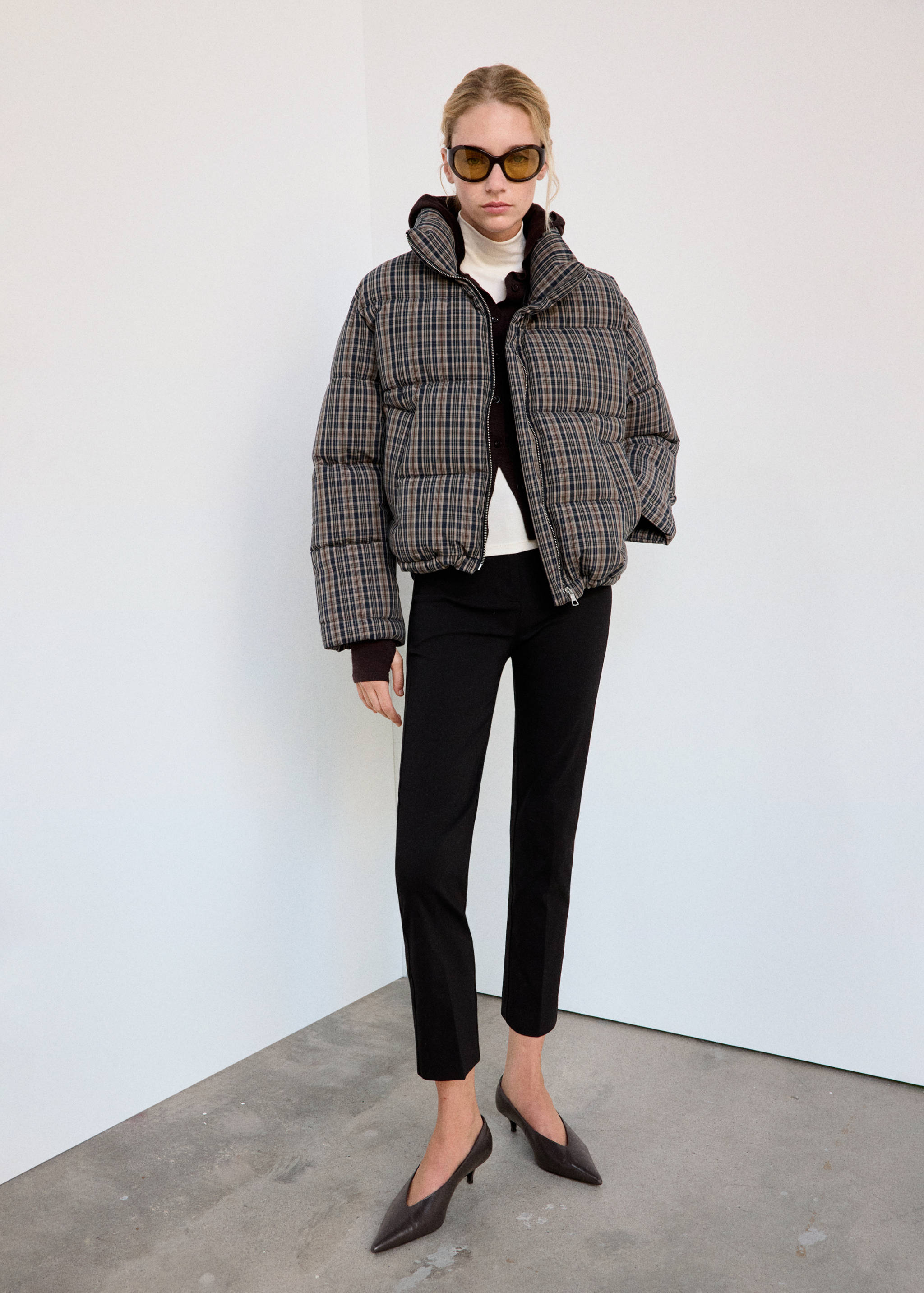 Brown and blue plaid quilted anorak with a high collar worn in an outfit look.