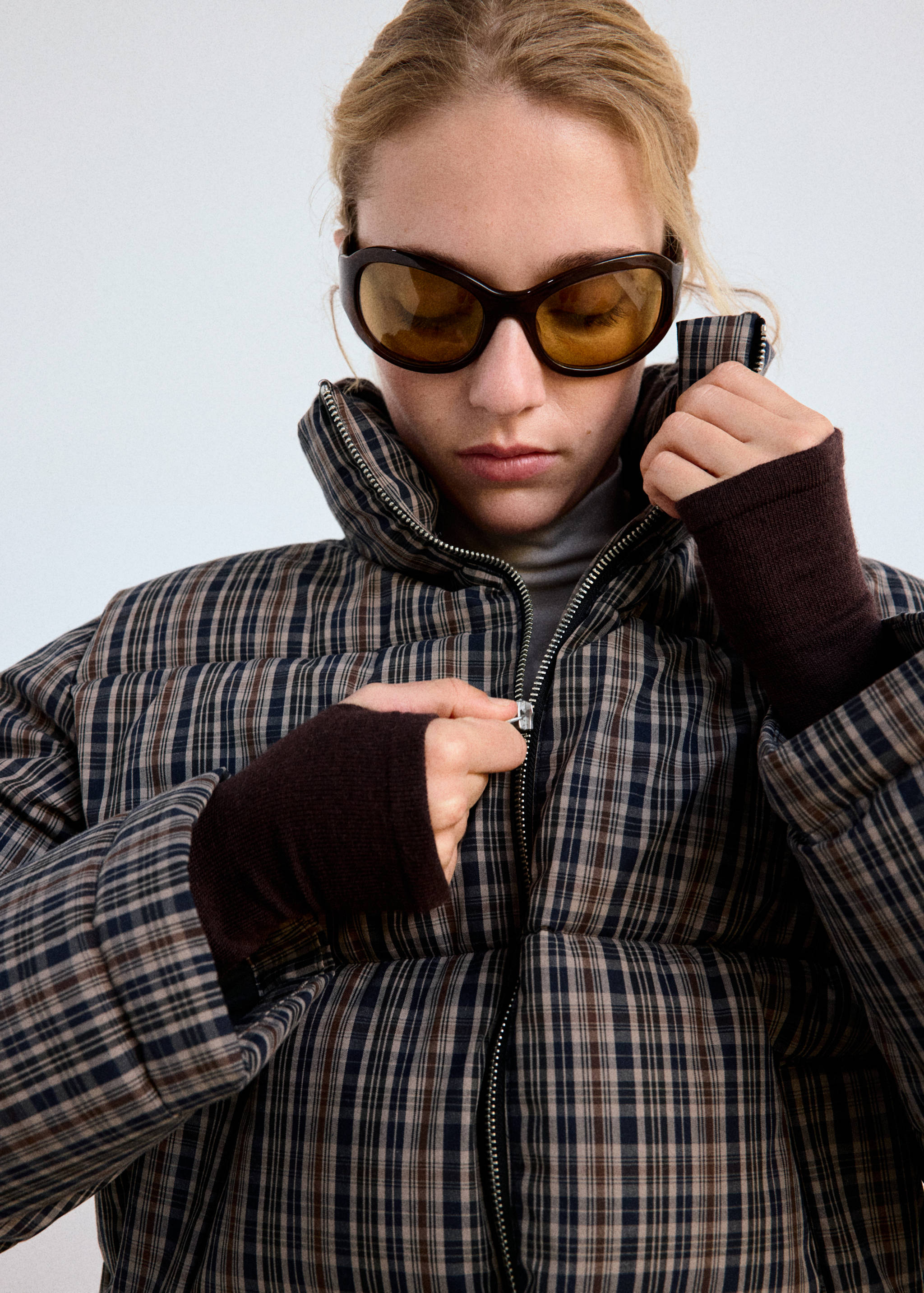 Close-up of a plaid anorak with a high neck and front zip.