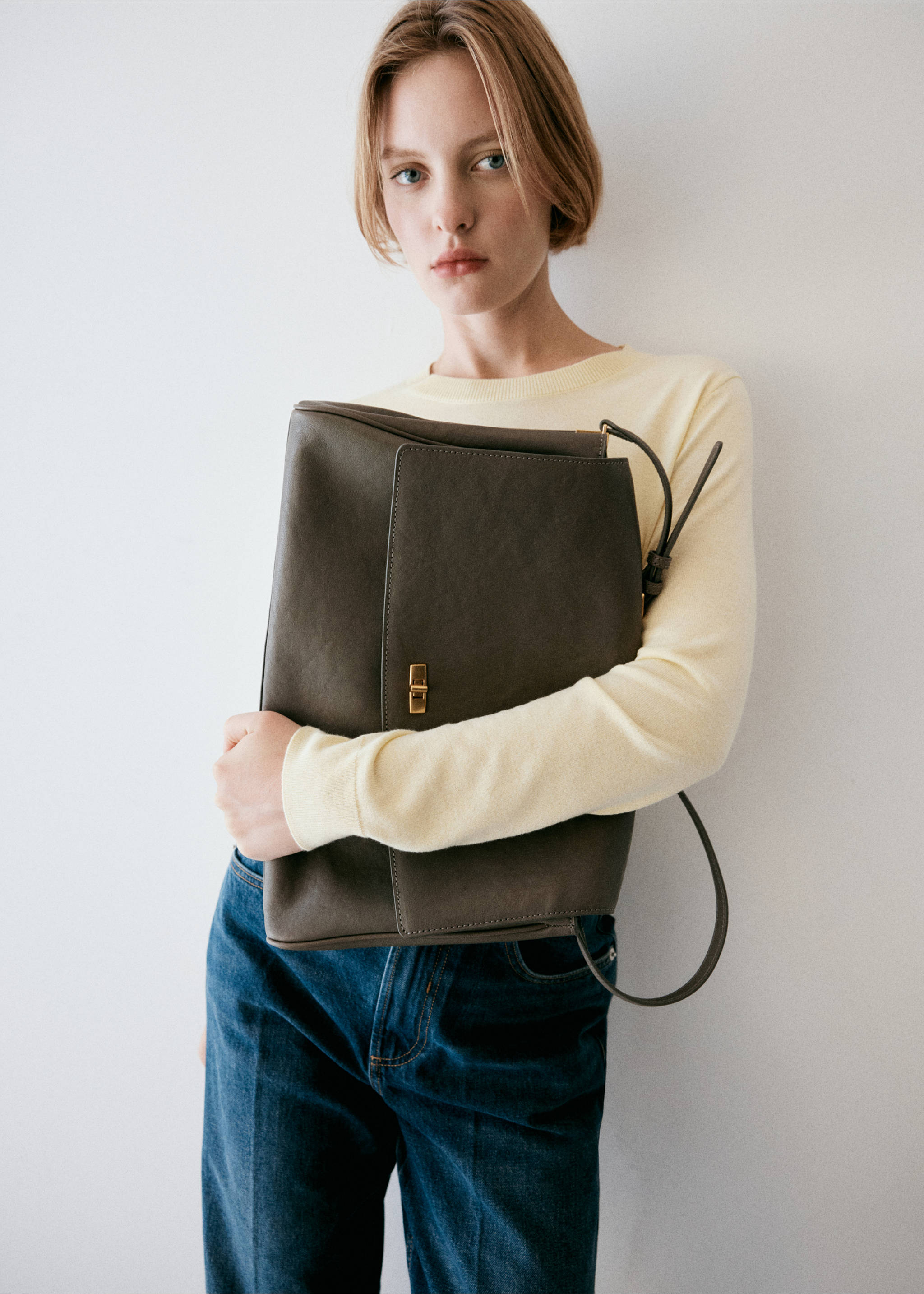 Light yellow crew-neck jersey worn with a dark grey-brown shoulder bag., Pastel Yellow. Ref: 37017777-00.