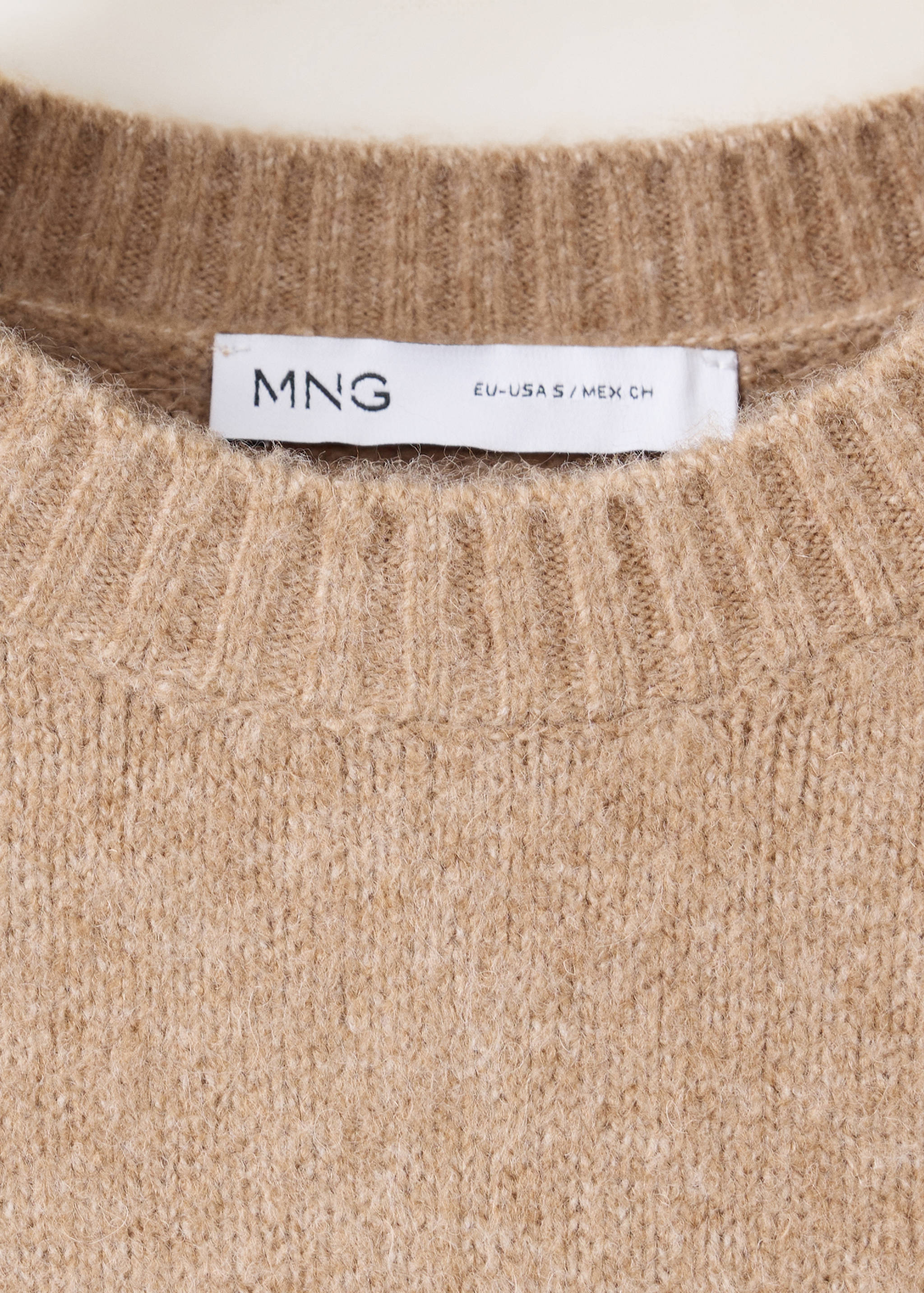 Close-up of a brown knit jersey featuring a ribbed crew neckline.