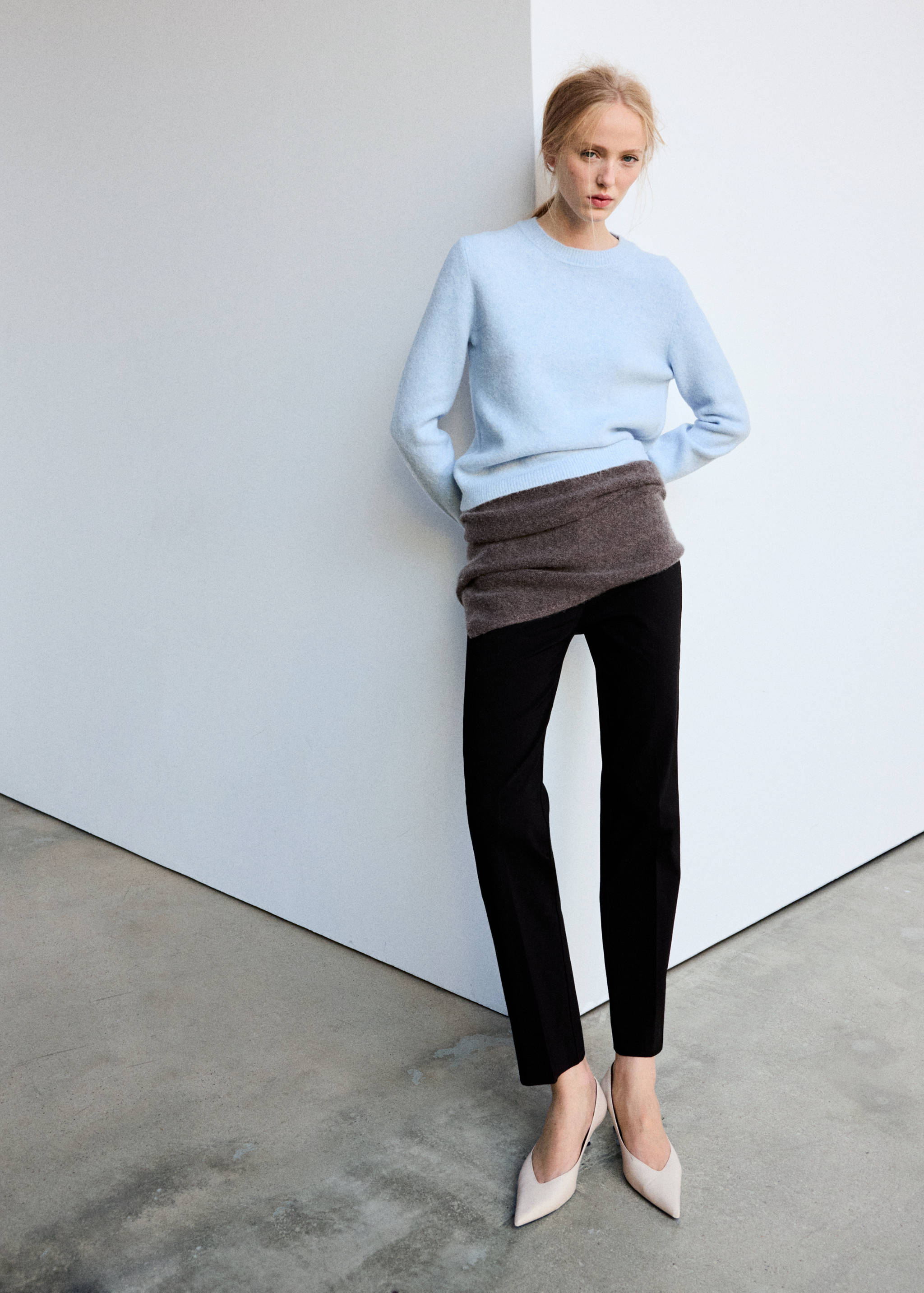 Light blue crew neck jersey with a fuzzy texture, worn with slim black trousers.