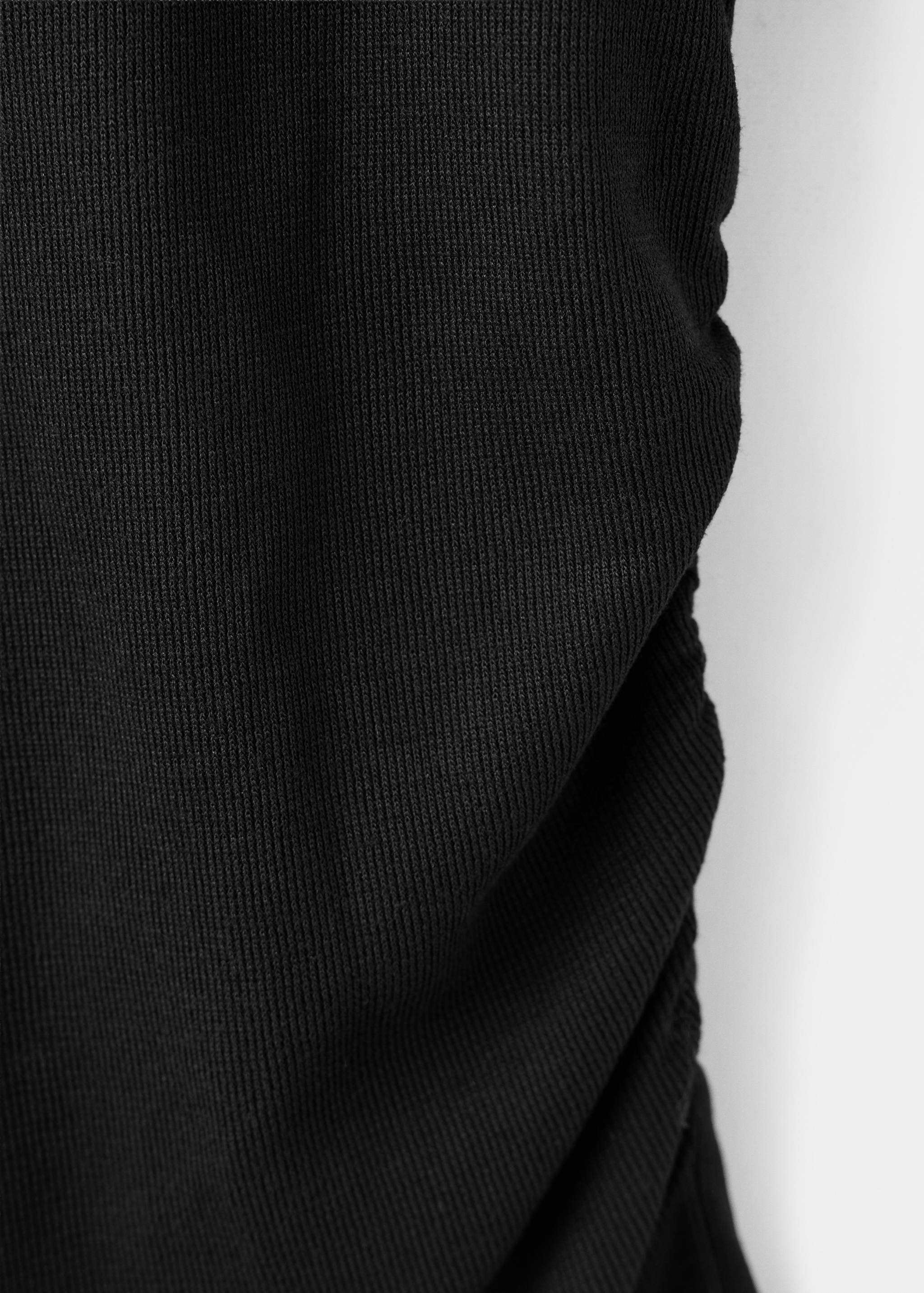 Detalle del tejido de canalé negro en el top.