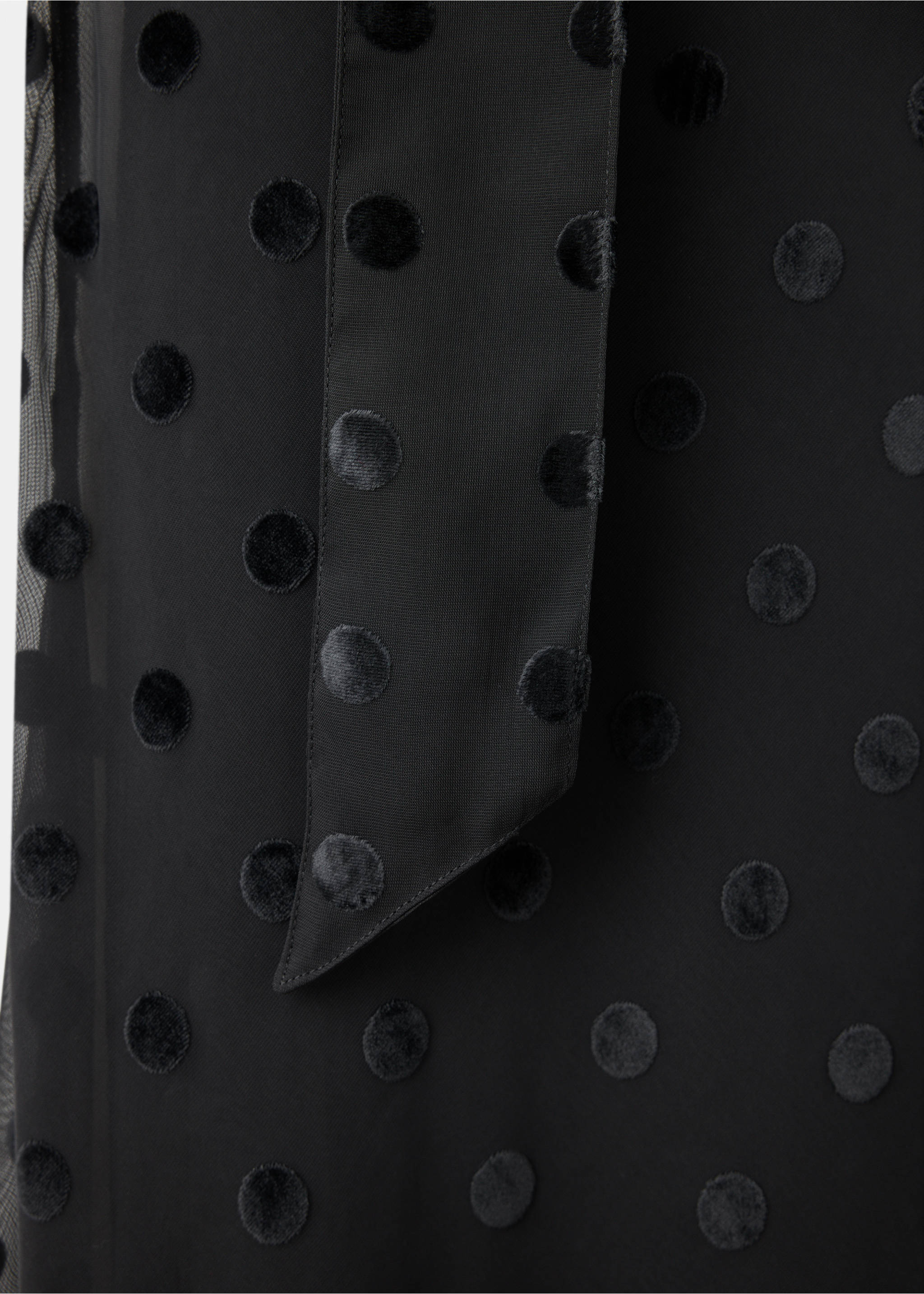 Close-up of a black dress fabric with velvet polka dots and a tie detail., Black. Ref: 37017785-00.